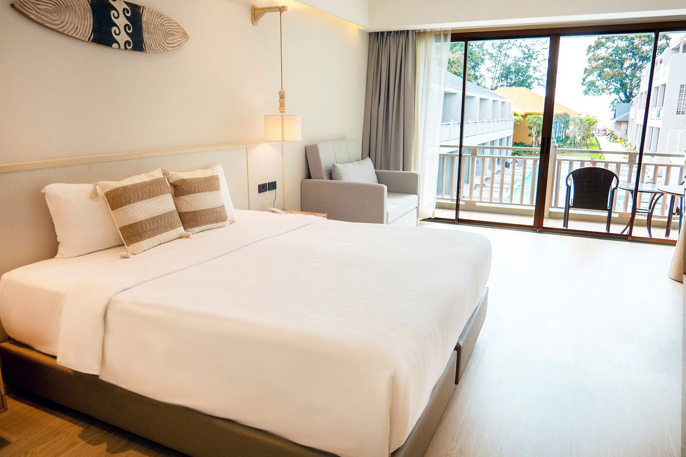 Et hotelværelse med en dobbeltseng, sofa og balkon med udsigt. (AI-genereret tekst)