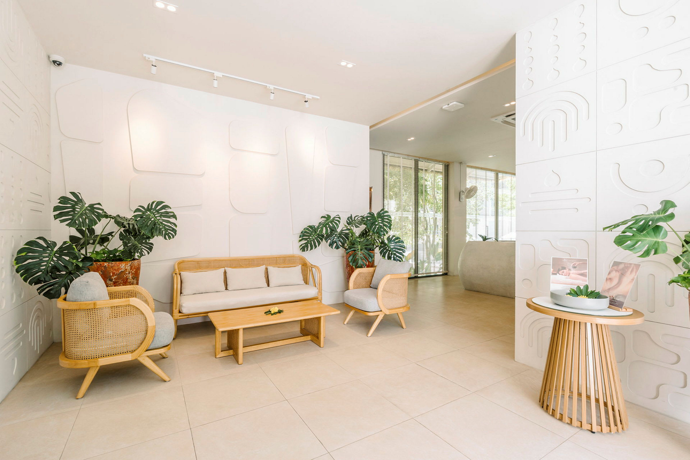 Lys og moderne lobby med planter og siddegrupper i lyst trædesign. (AI-genereret tekst)