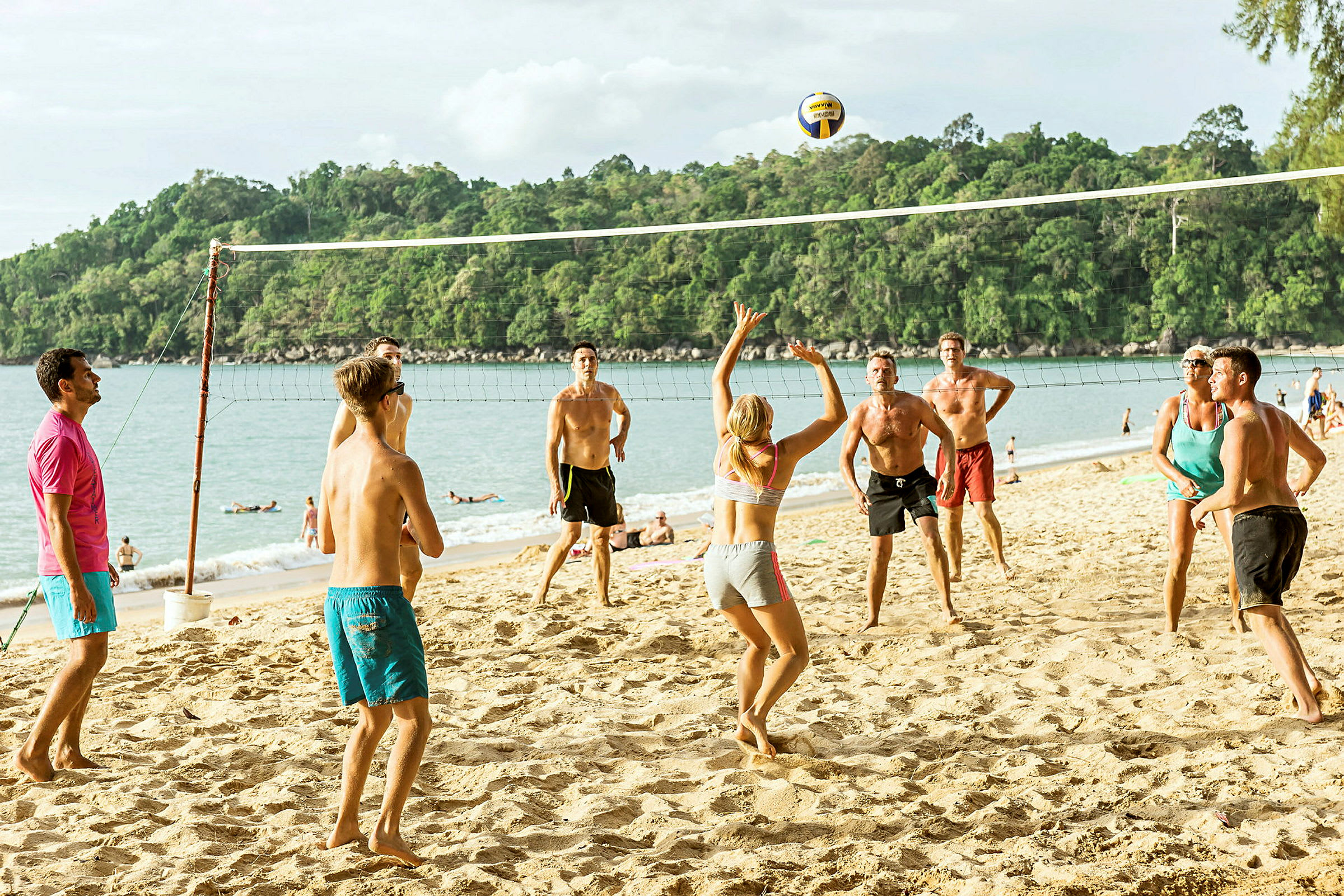 Folk spiller volleyball på en strand. (AI-genereret tekst)