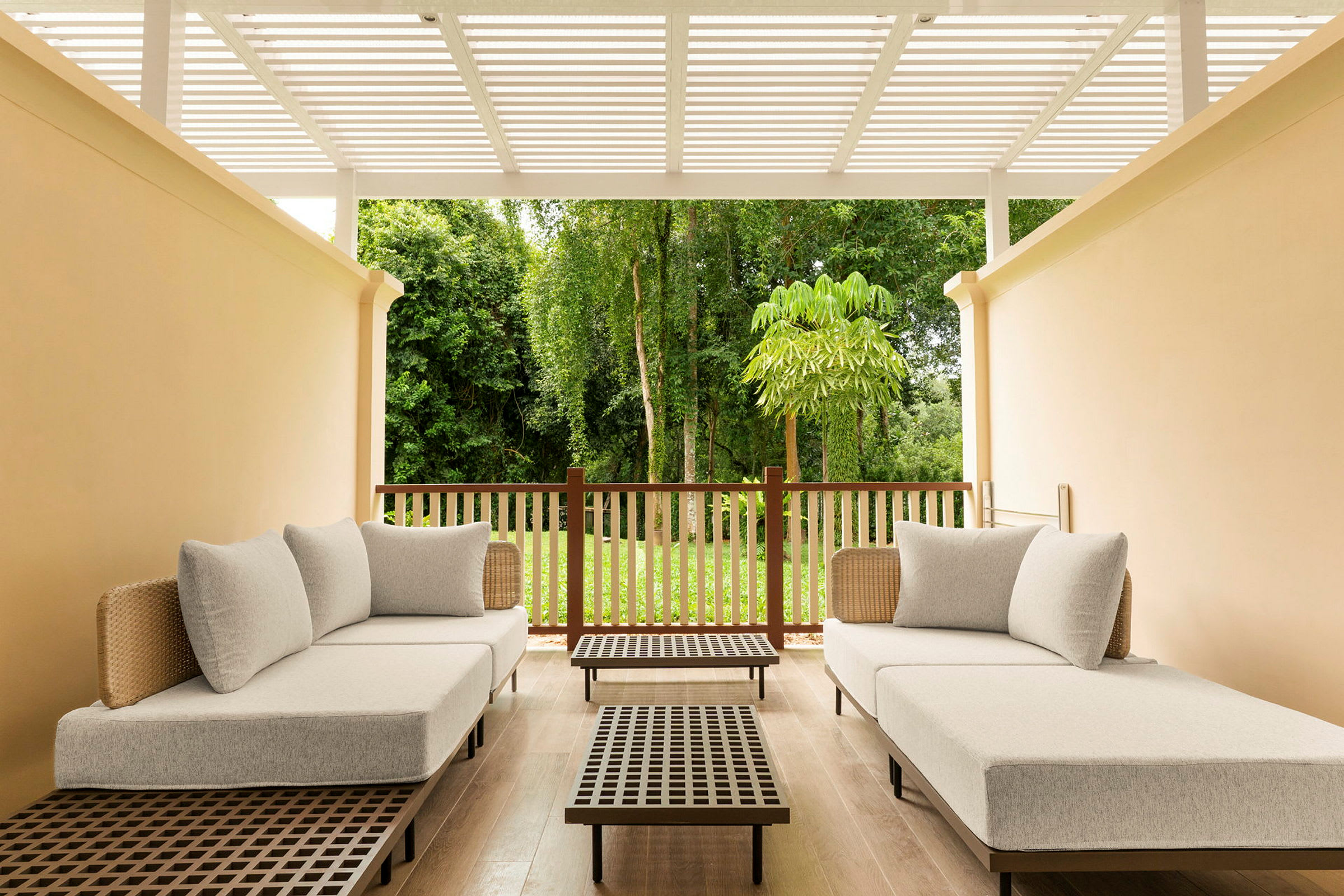 En terrasse med to sofaer, et lavt bord og udsigt til en frodig have. (AI-genereret tekst)