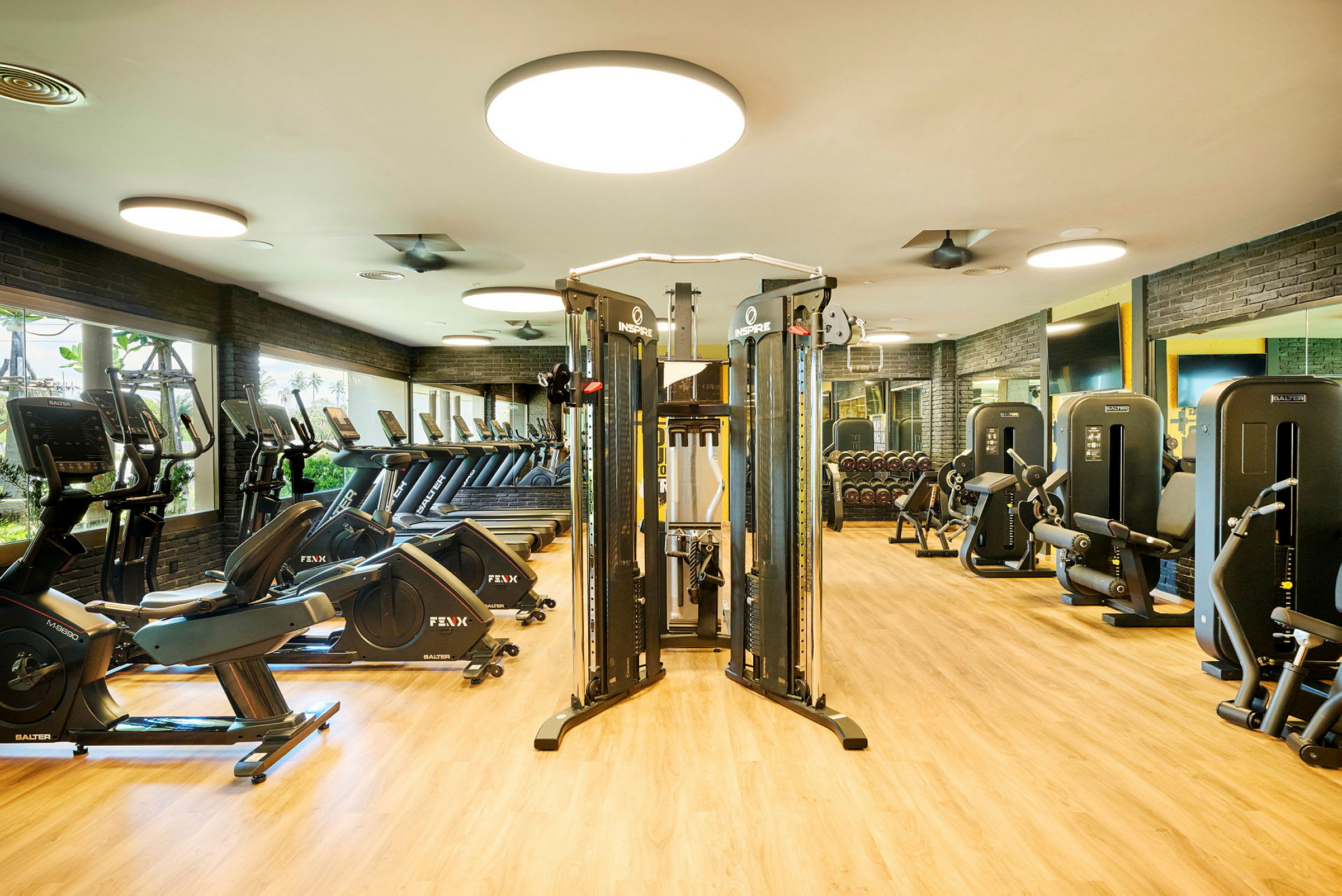 Fitnesscenter med træningsmaskiner og udstyr, såsom motionscykler og løbebånd. (AI-genereret tekst)