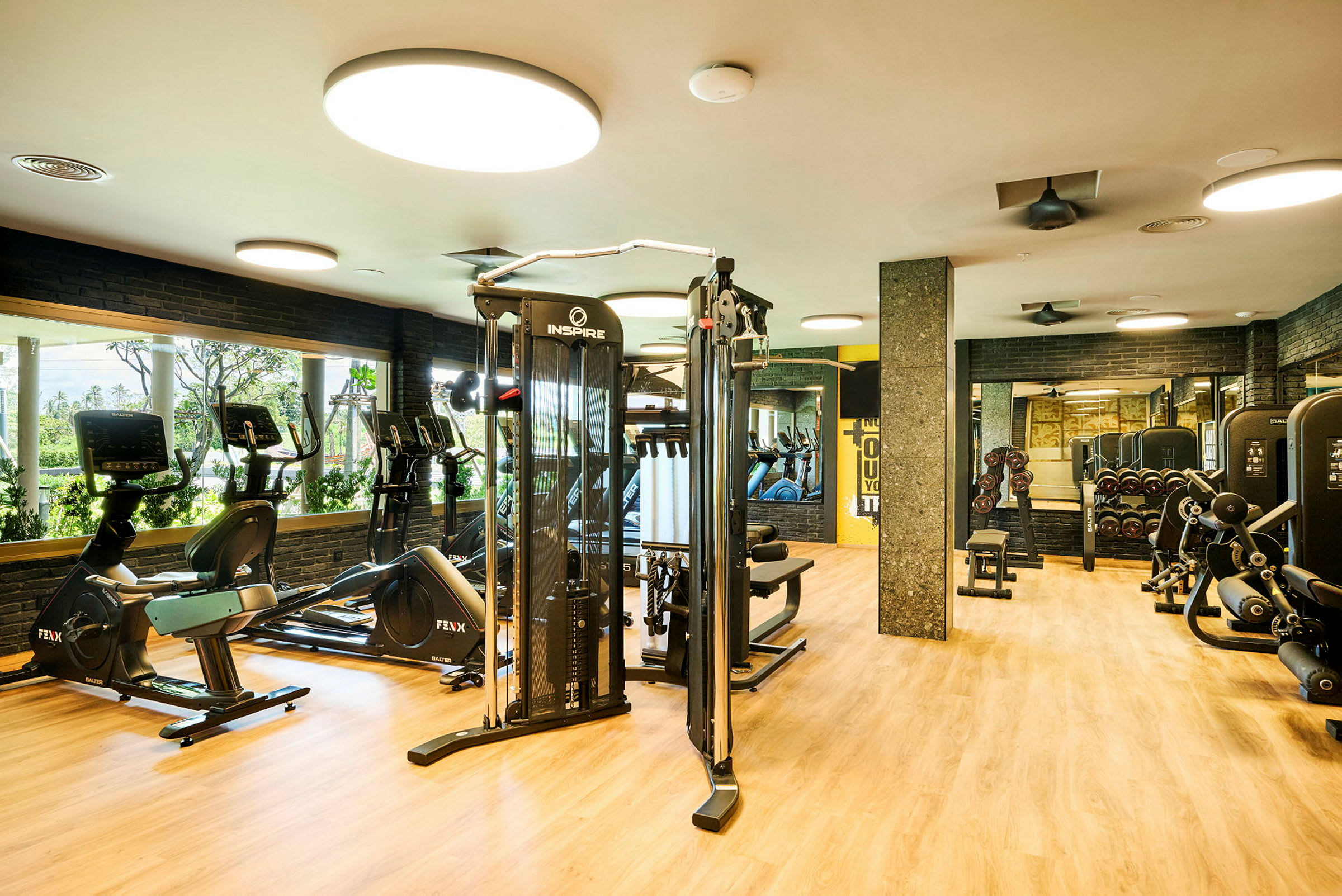 Et fitnesscenter med træningsmaskiner, cykler og spejle på væggene. (AI-genereret tekst)