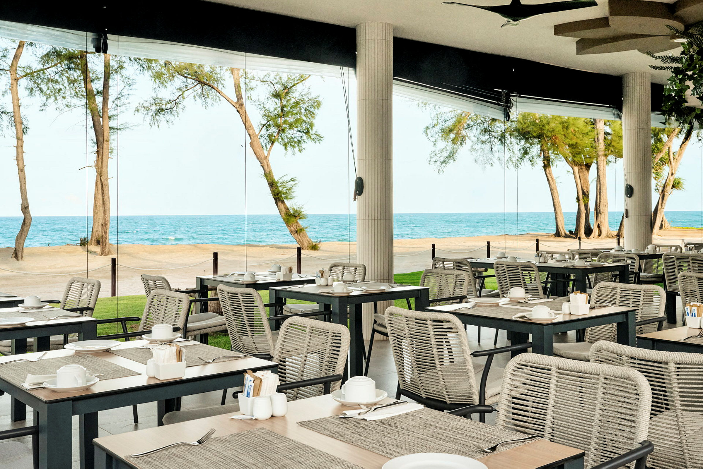 Restaurant med udendørs servering og havudsigt. (AI-genereret tekst)