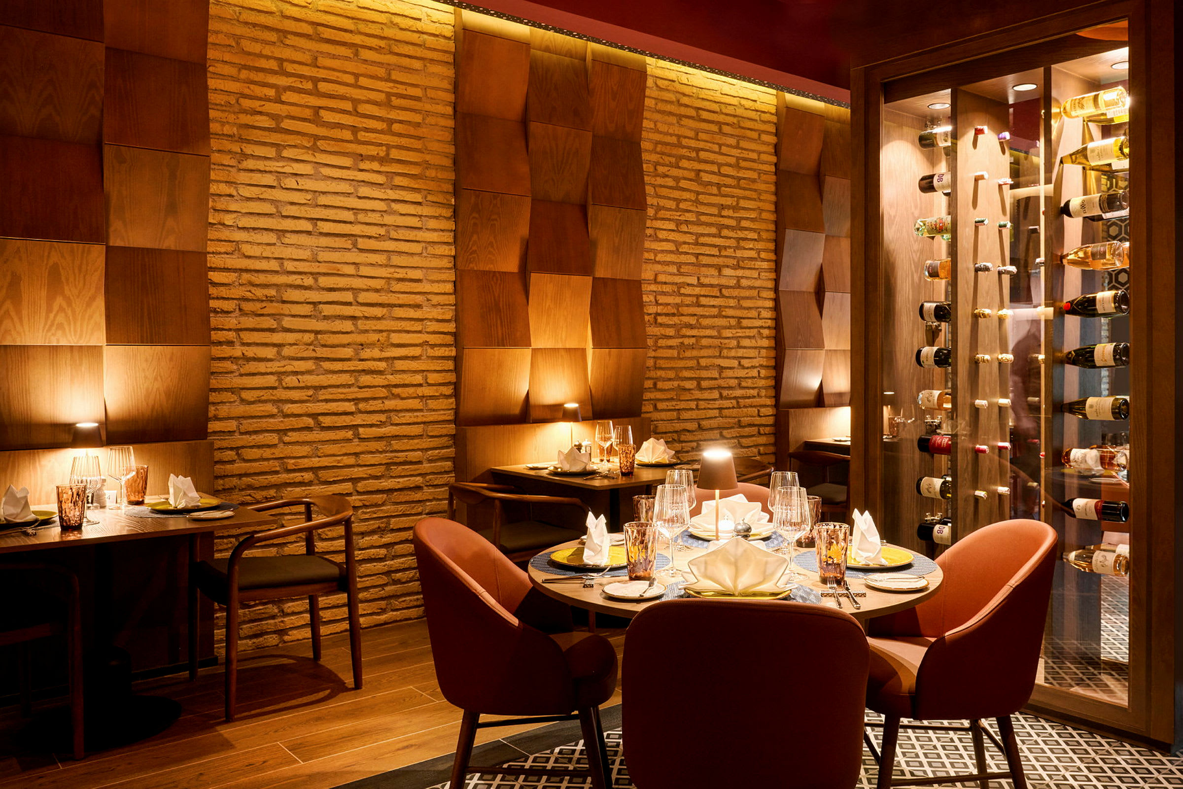 Et elegant restaurantinteriør med opdækkede borde og blød belysning mod vægge af mursten og træpanel. (AI-genereret tekst)