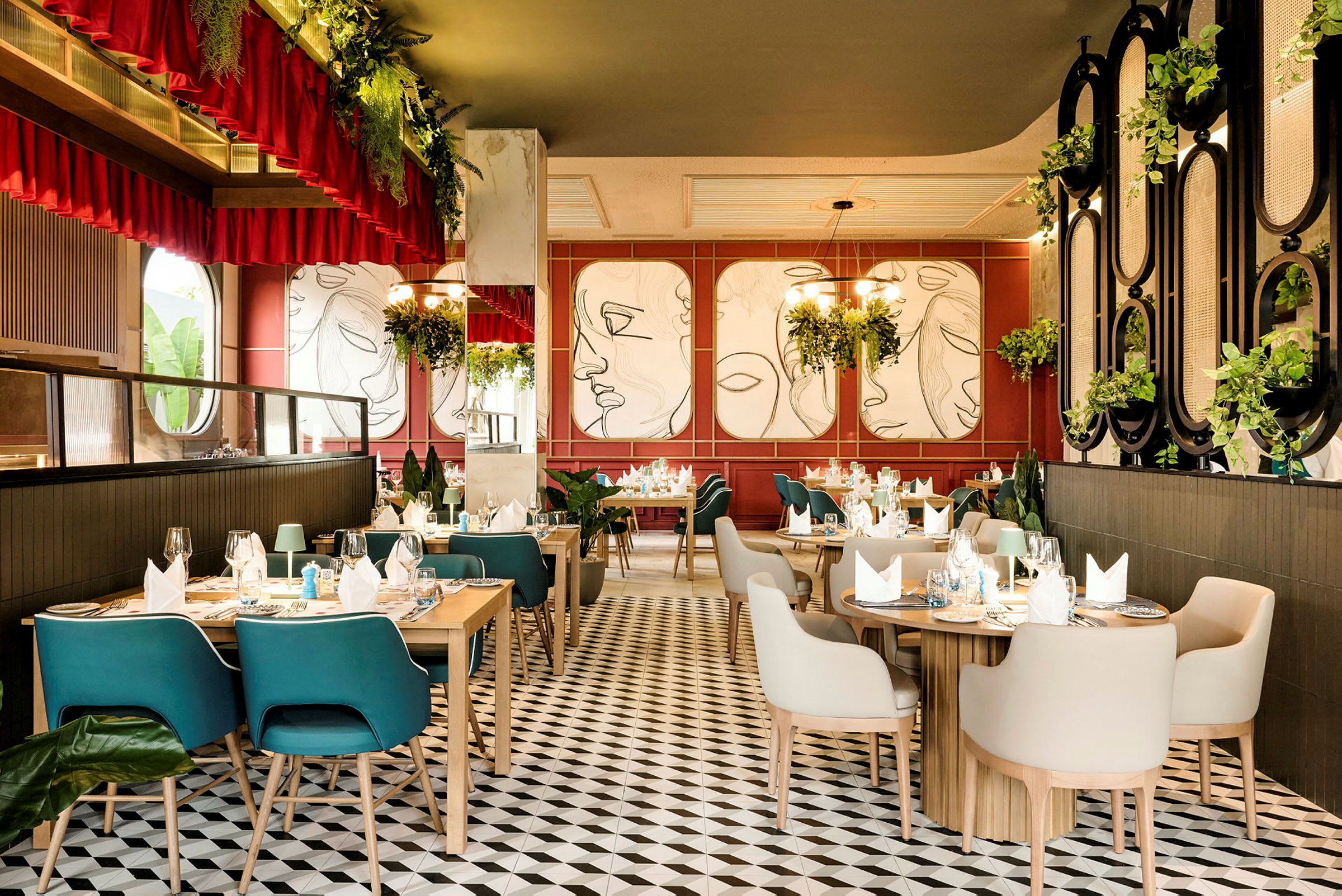En elegant indrettet restaurant med træborde, komfortable stole og moderne vægkunst på væggene. Rummet har meget grønt og loftsbelysning. (AI-genereret tekst)
