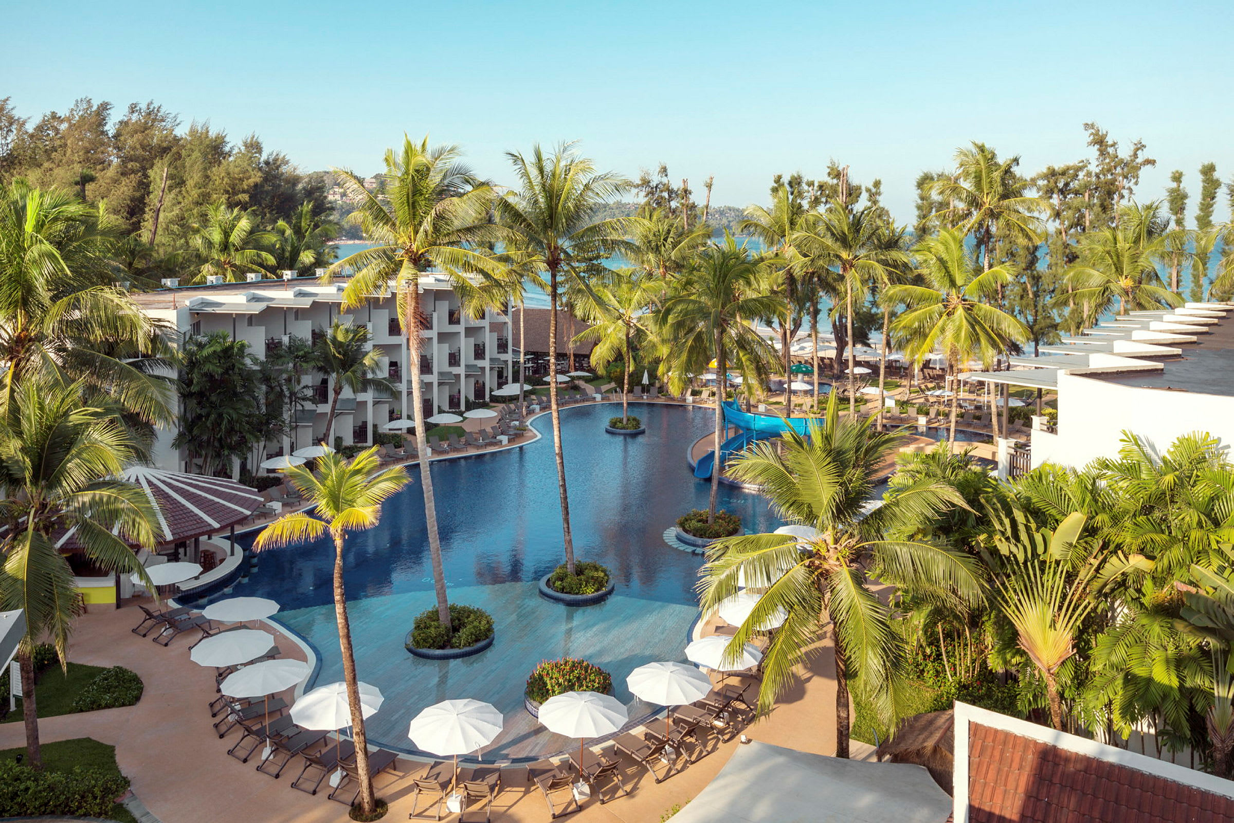 En oversigt over et hotelresort med pool og palmer. (AI-genereret tekst)