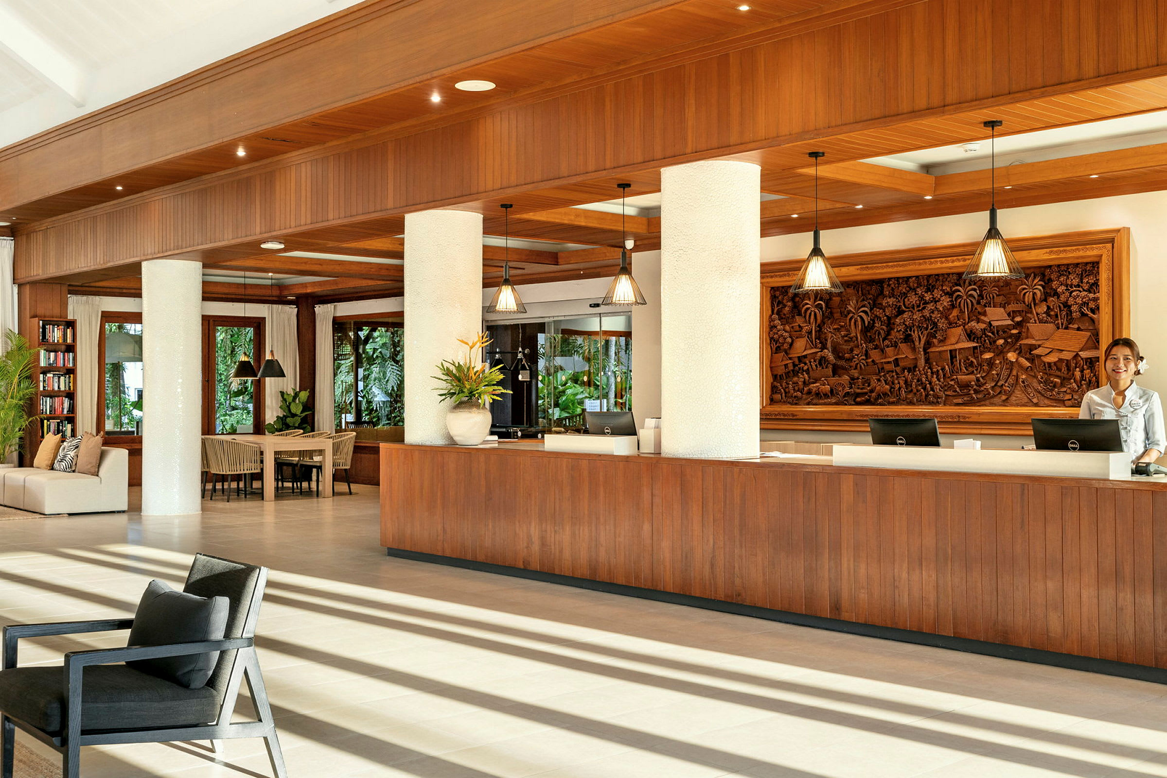 Receptionen på et moderne hotel med træelementer og dekorative udskæringer på væggen. (AI-genereret tekst)