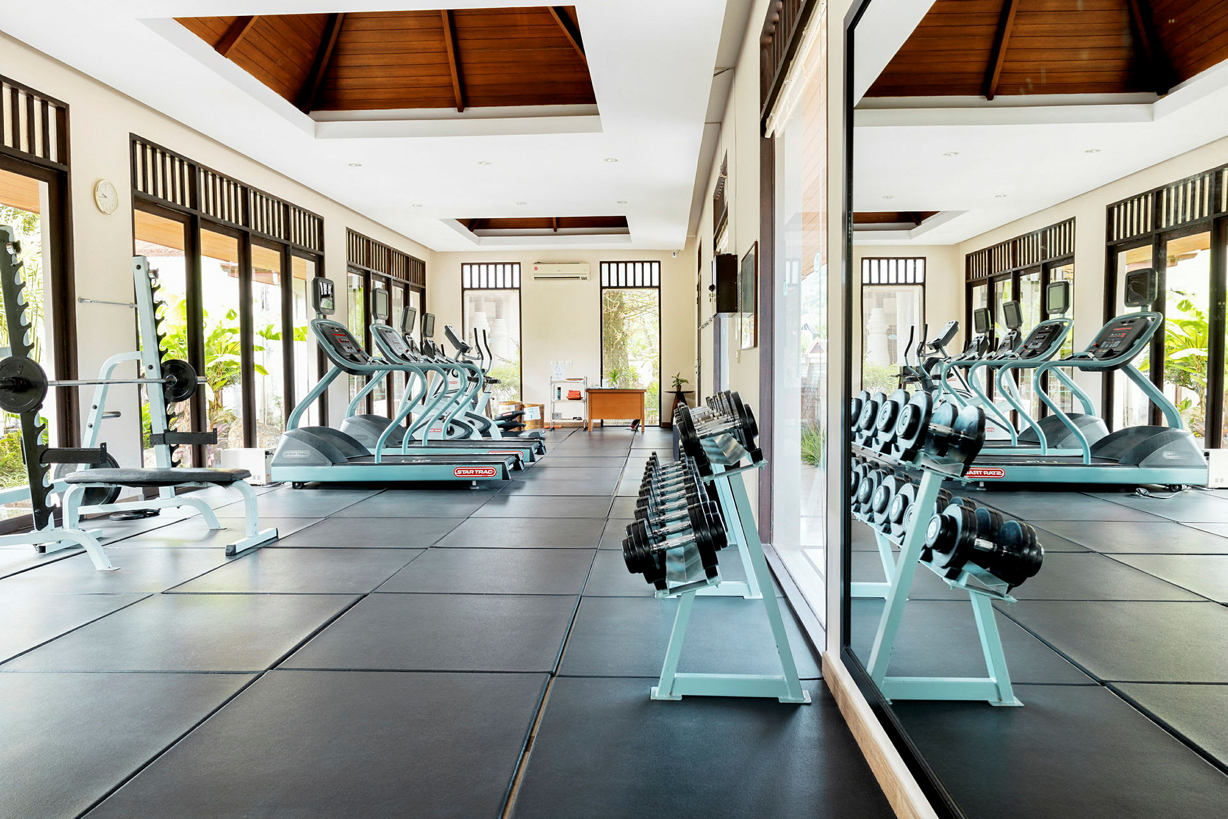 Et fitnesscenter med træningsudstyr såsom løbebånd, håndvægte og bænkpres. (AI-genereret tekst)