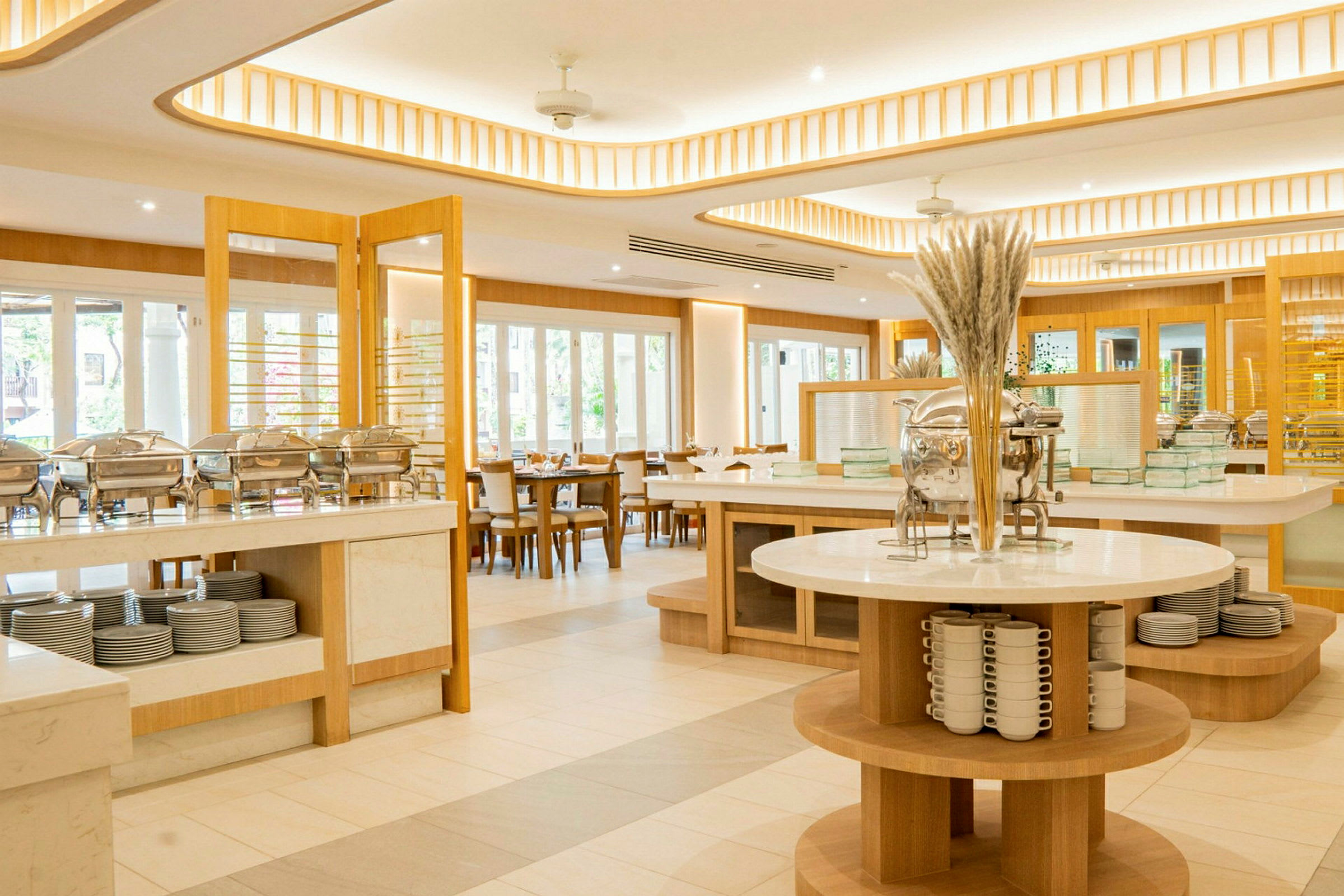 Lyst indrettet buffetrestaurant med moderne møbler og serveringsstationer. (AI-genereret tekst)