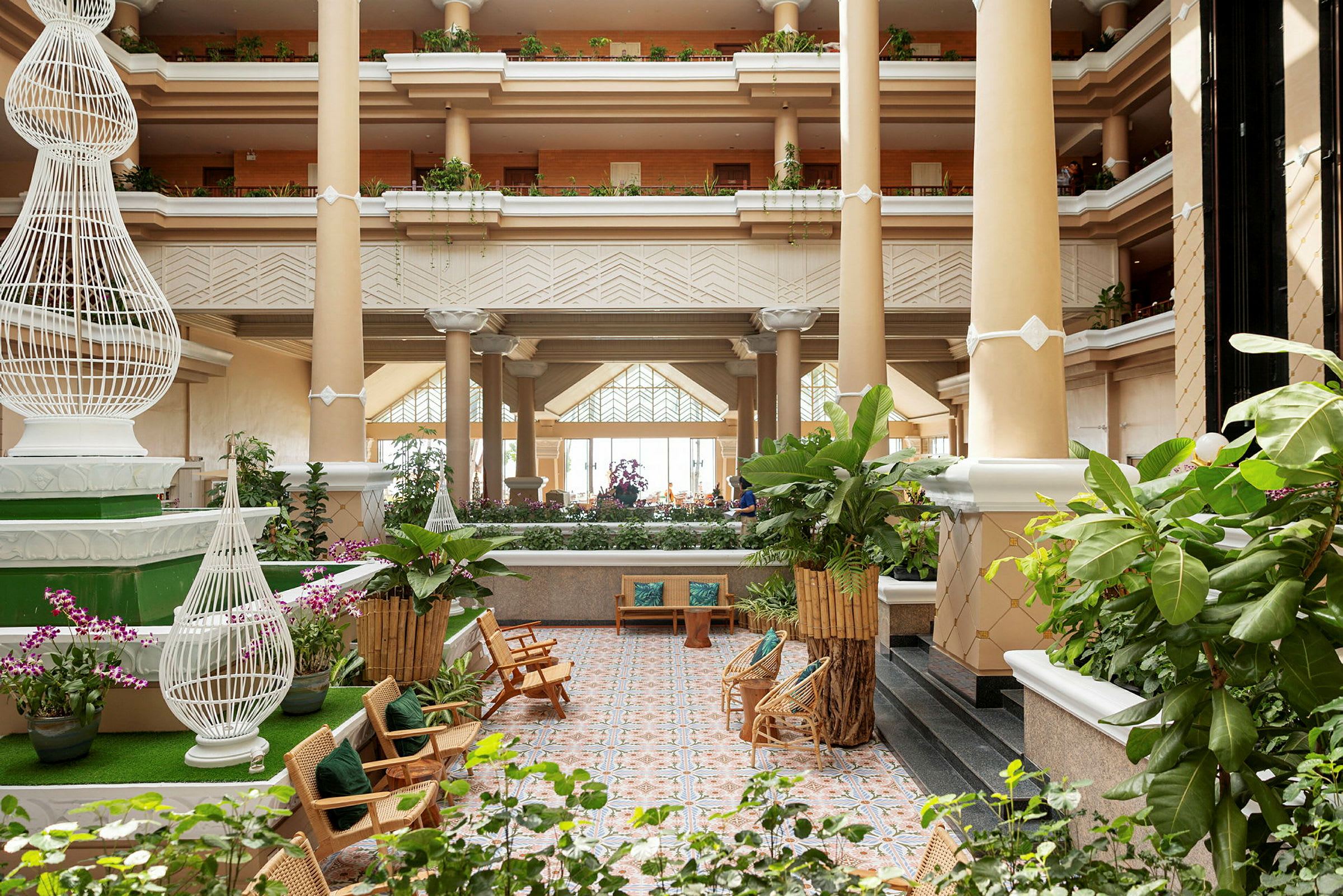 Lys og rummelig hotellobby med grønne planter og siddepladser. (AI-genereret tekst)