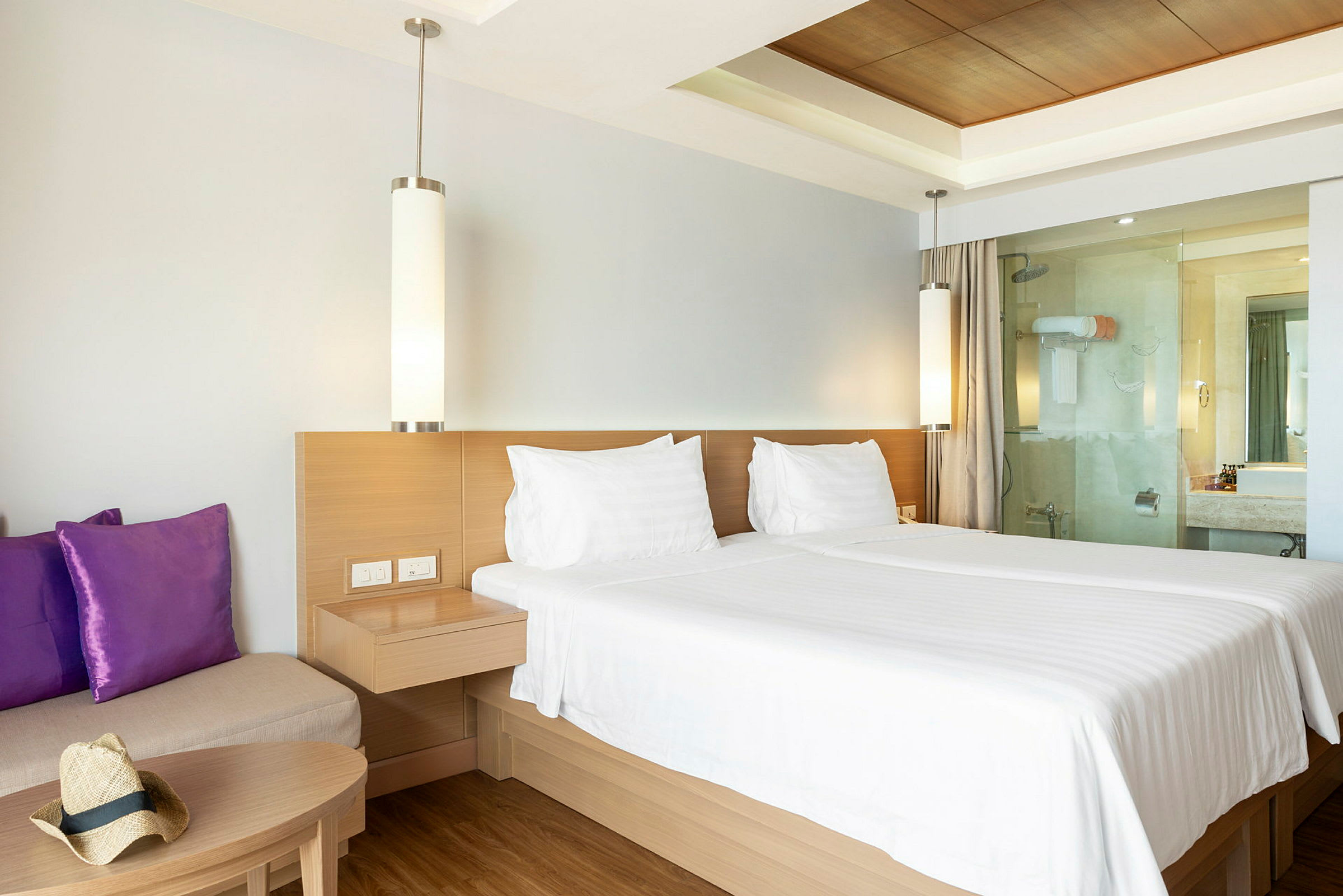 Hotelværelse med dobbeltseng, sofa og badeværelse. (AI-genereret tekst)