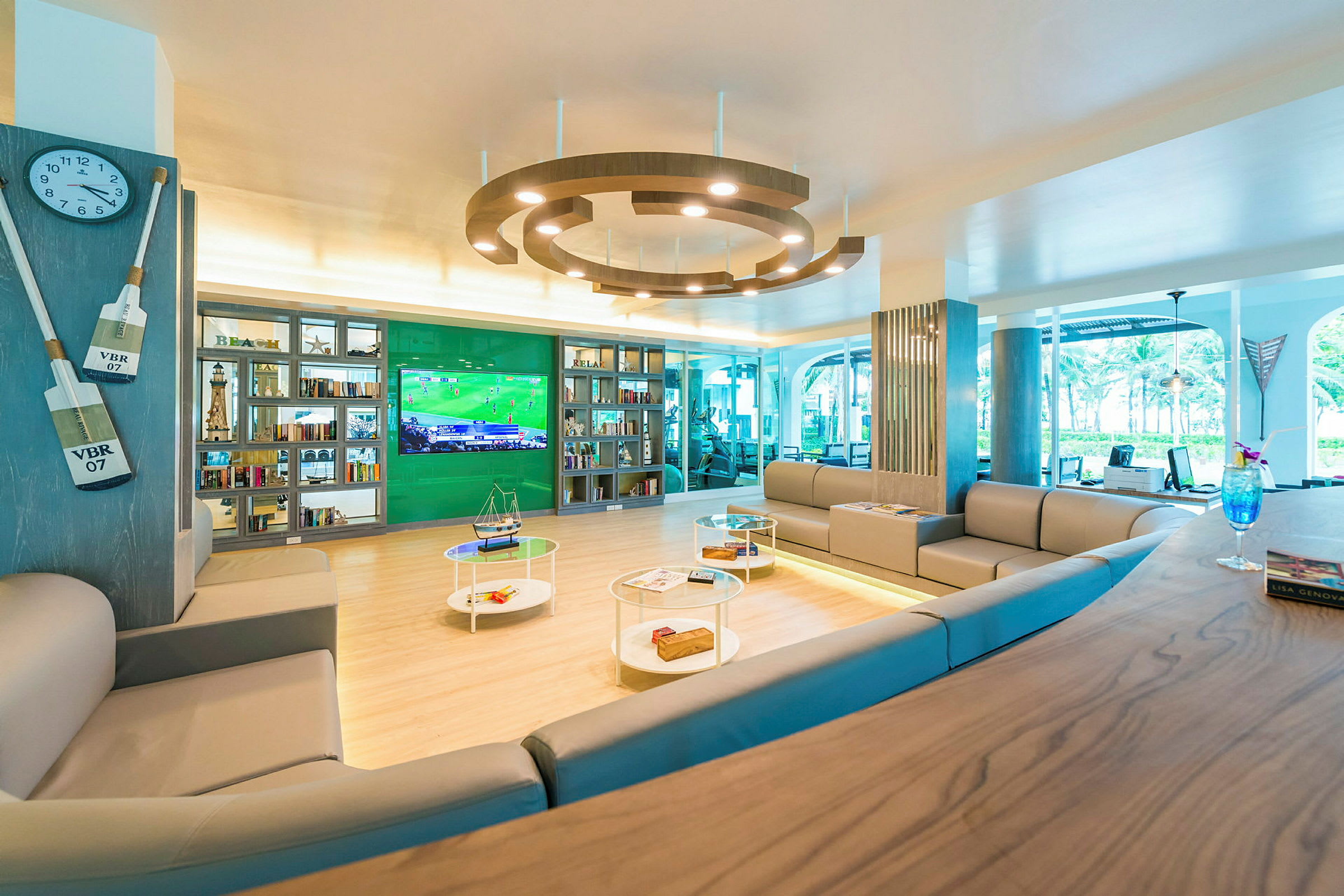 Loungeområde med sofaer, hylder og et stort TV. (AI-genereret tekst)