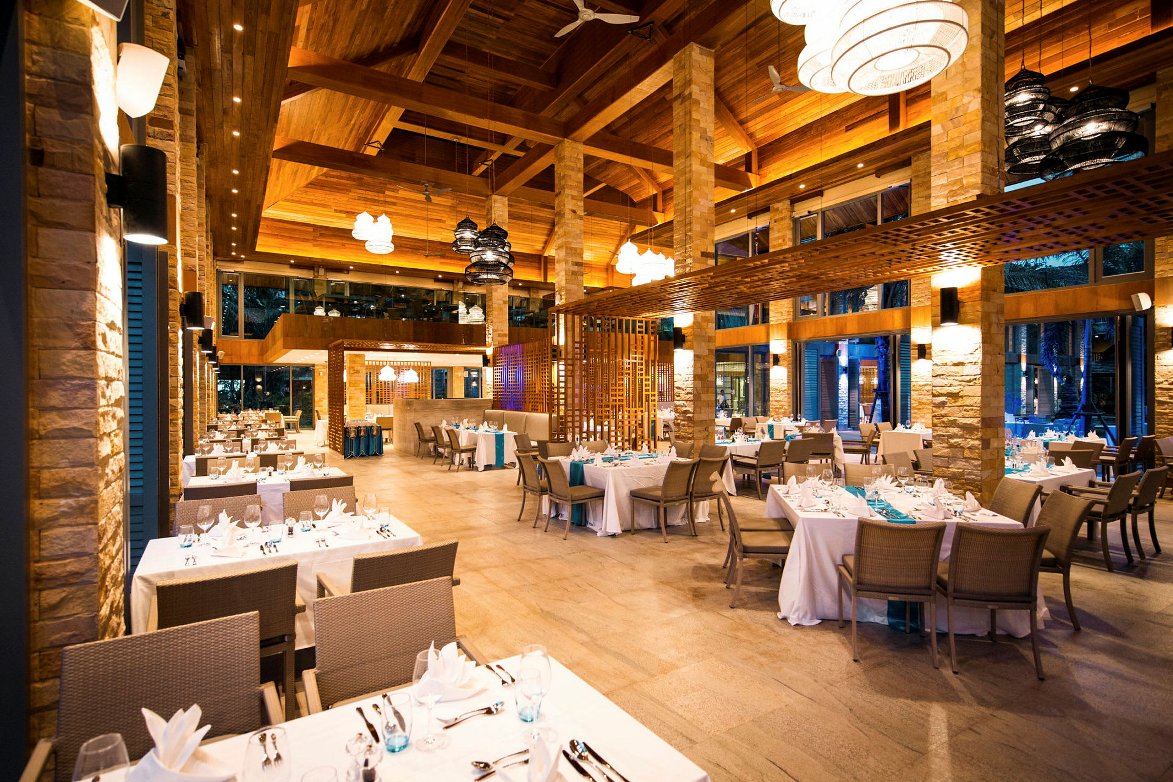 Interiør af en elegant restaurant med opdækkede borde og moderne lamper. (AI-genereret tekst)