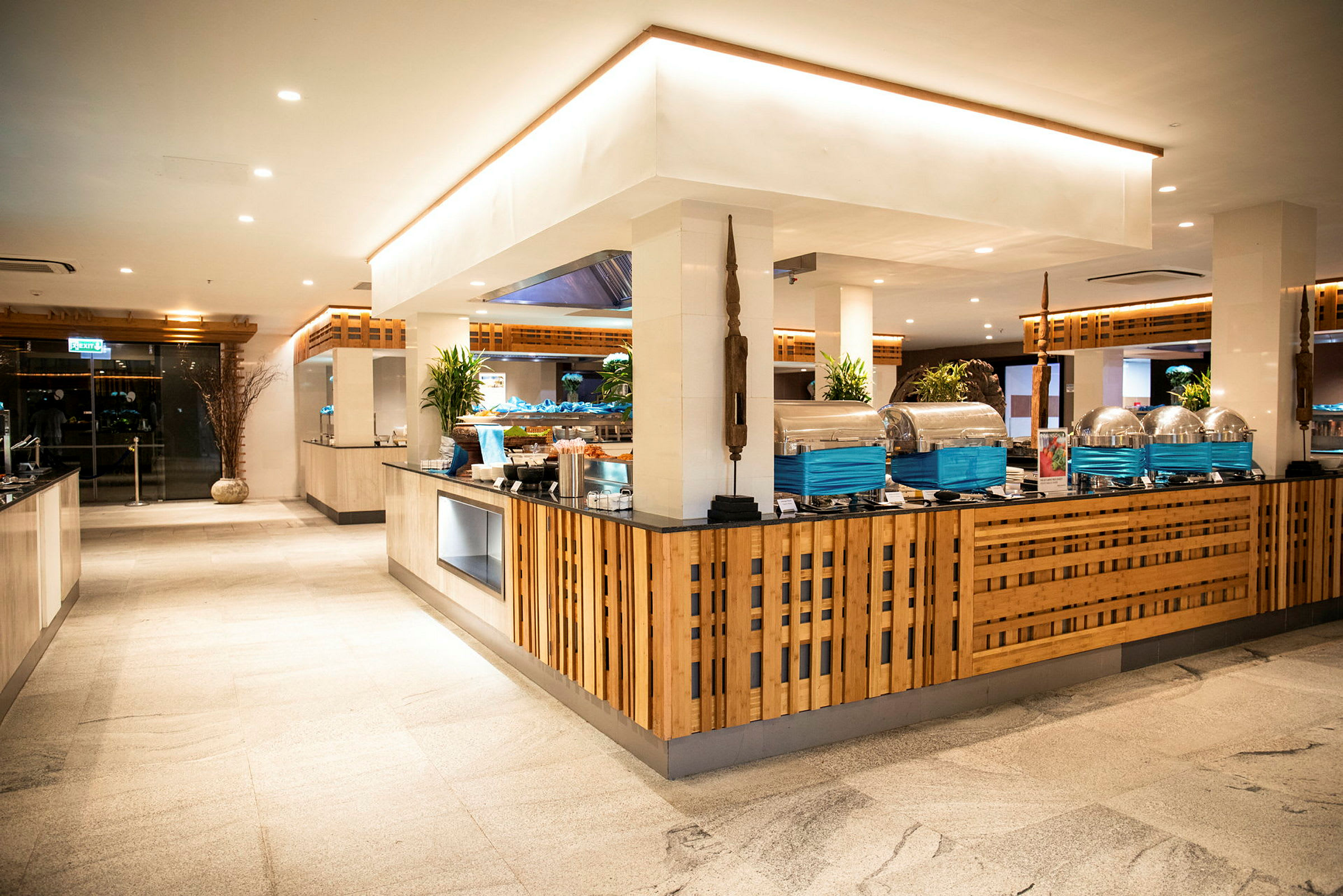 Et buffetområde med træinspireret indretning og rustfri serveringsstationer. (AI-genereret tekst)