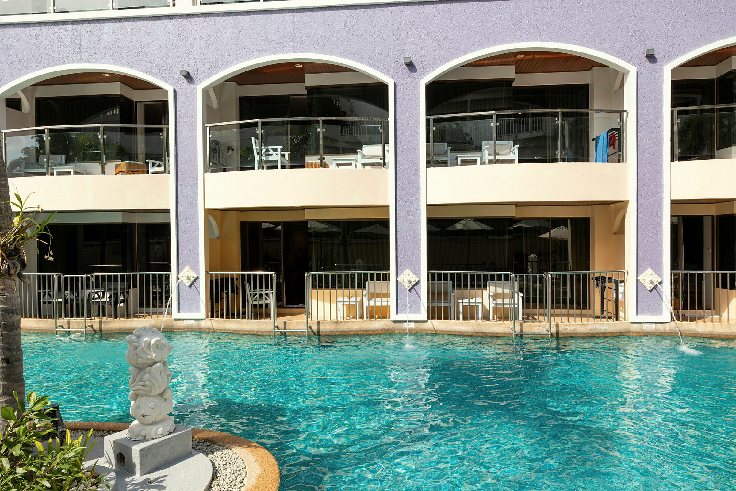 Hotellets facade med altaner over poolen. (AI-genereret tekst)