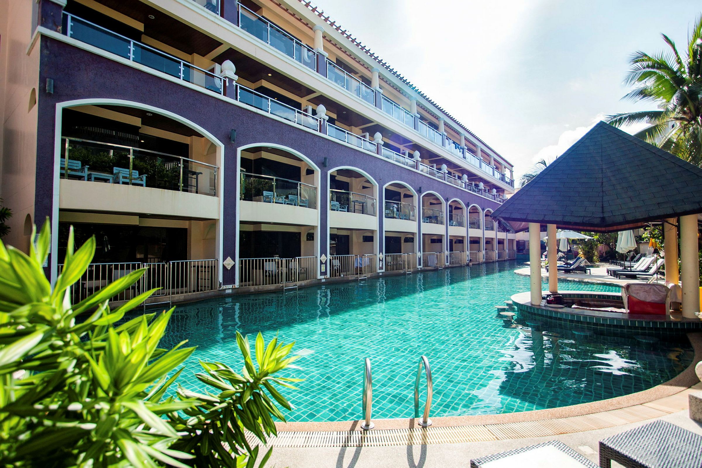 Hotel med flere etager ved en stor pool. (AI-genereret tekst)