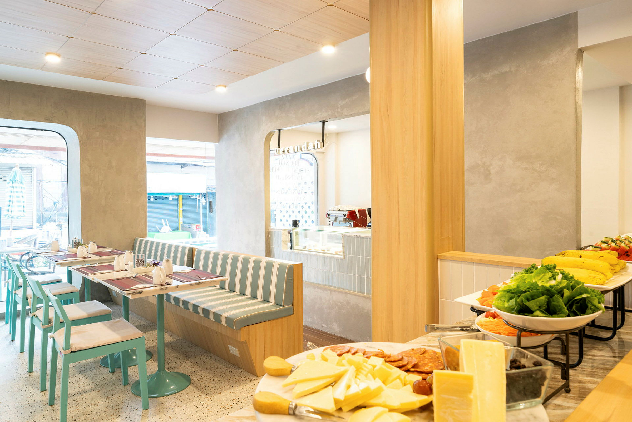 Et billede af en lys café med moderne møbler og morgenmadsbuffet. (AI-genereret tekst)