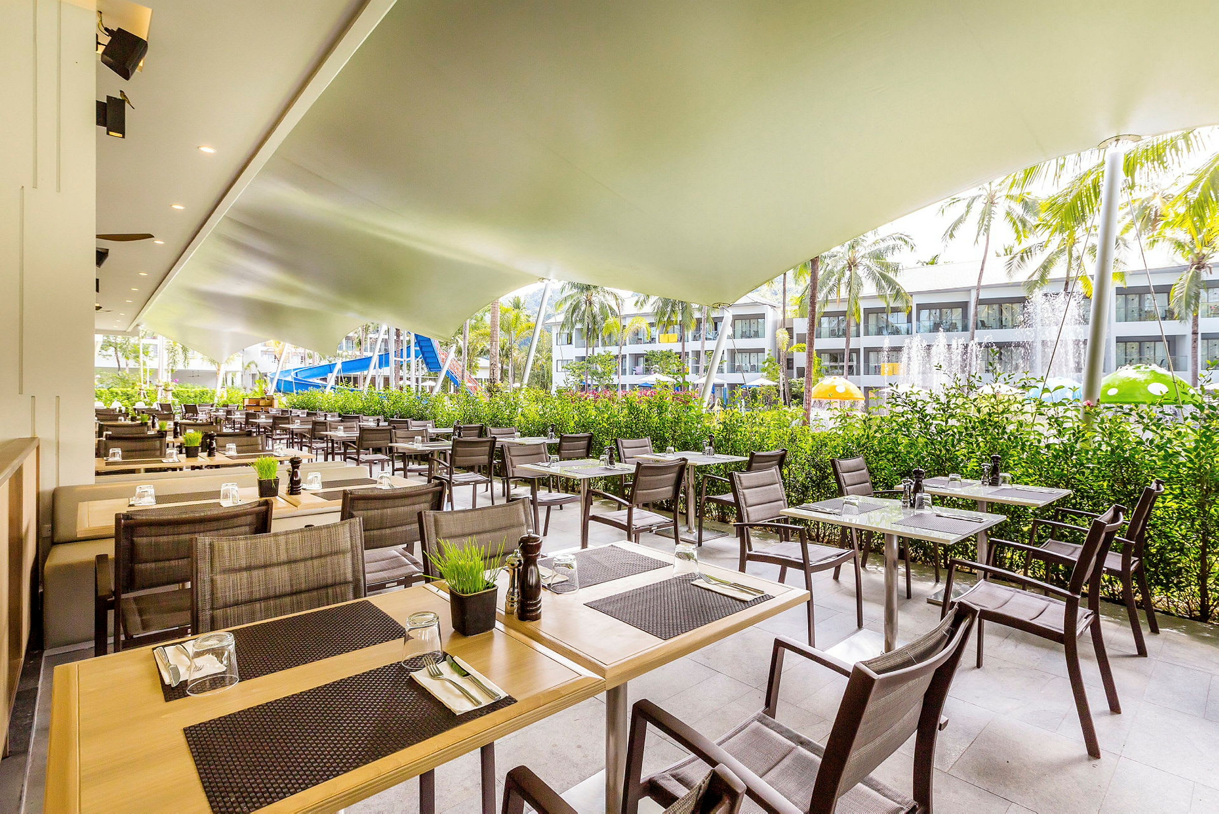 Udendørs restaurant med borde og stole under et tag. (AI-genereret tekst)