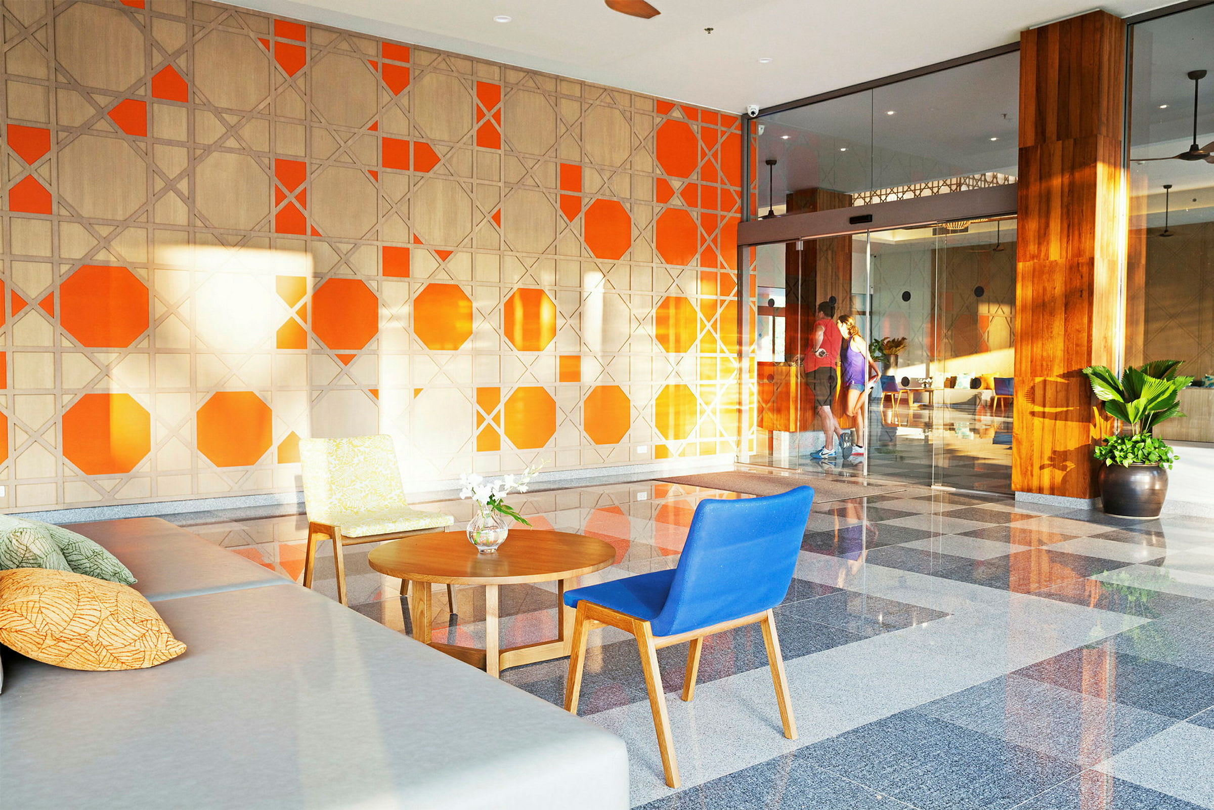 Lobbyen med orange og beige vægdesign samt siddepladser. (AI-genereret tekst)