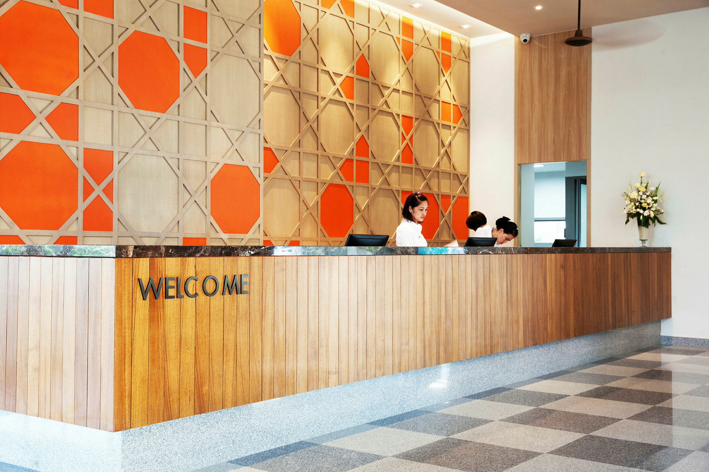 Reception med velkomstskilt og dekorativ orange væg. (AI-genereret tekst)