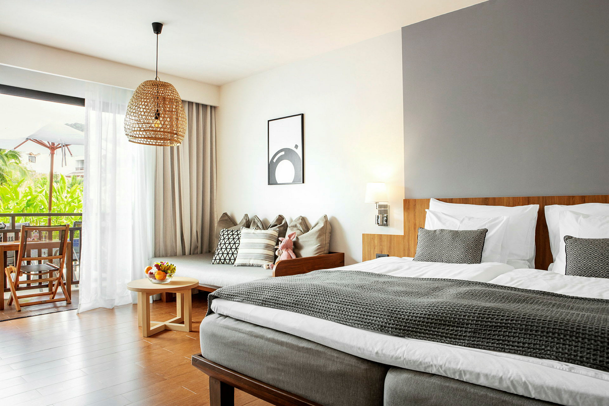 Moderne indrettet hotelværelse med seng, sofa og altan med udsigt. (AI-genereret tekst)