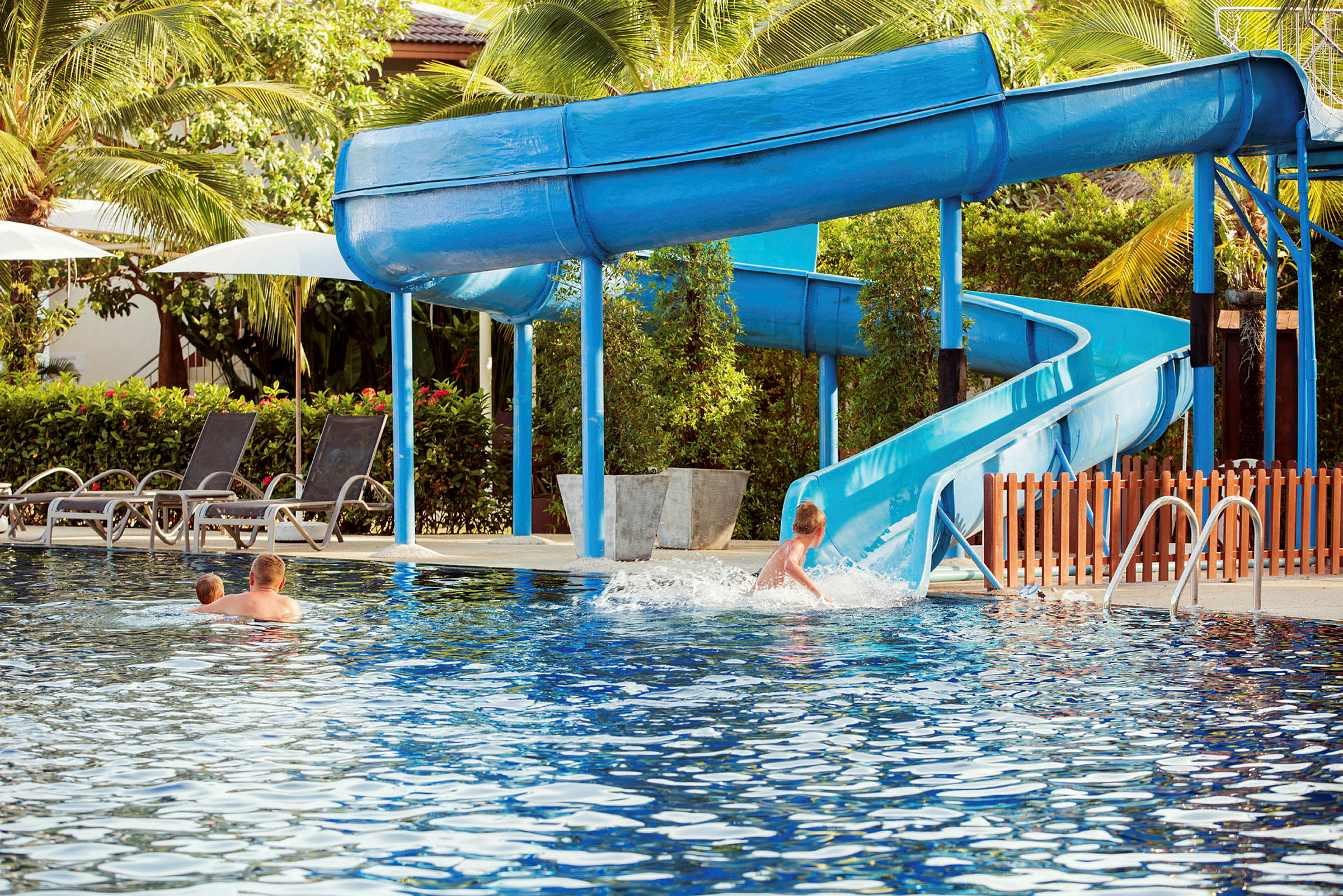 Børn leger i pool med rutsjebane. (AI-genereret tekst)