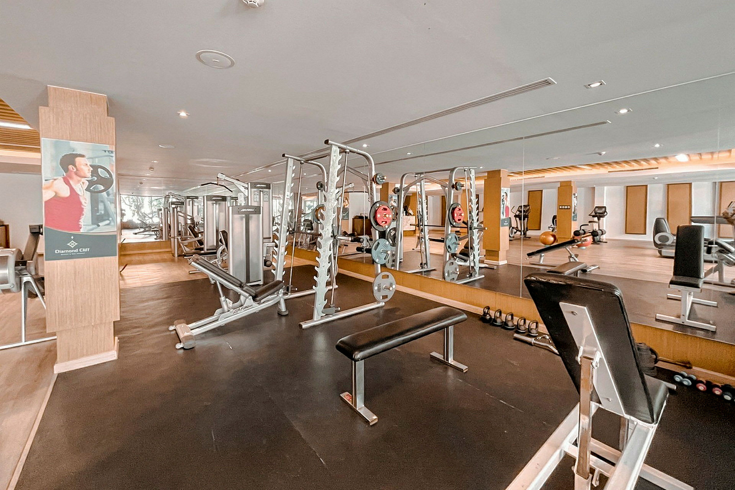 Et fitnesscenter med spejle, træningsmaskiner og træningsudstyr. (AI-genereret tekst)