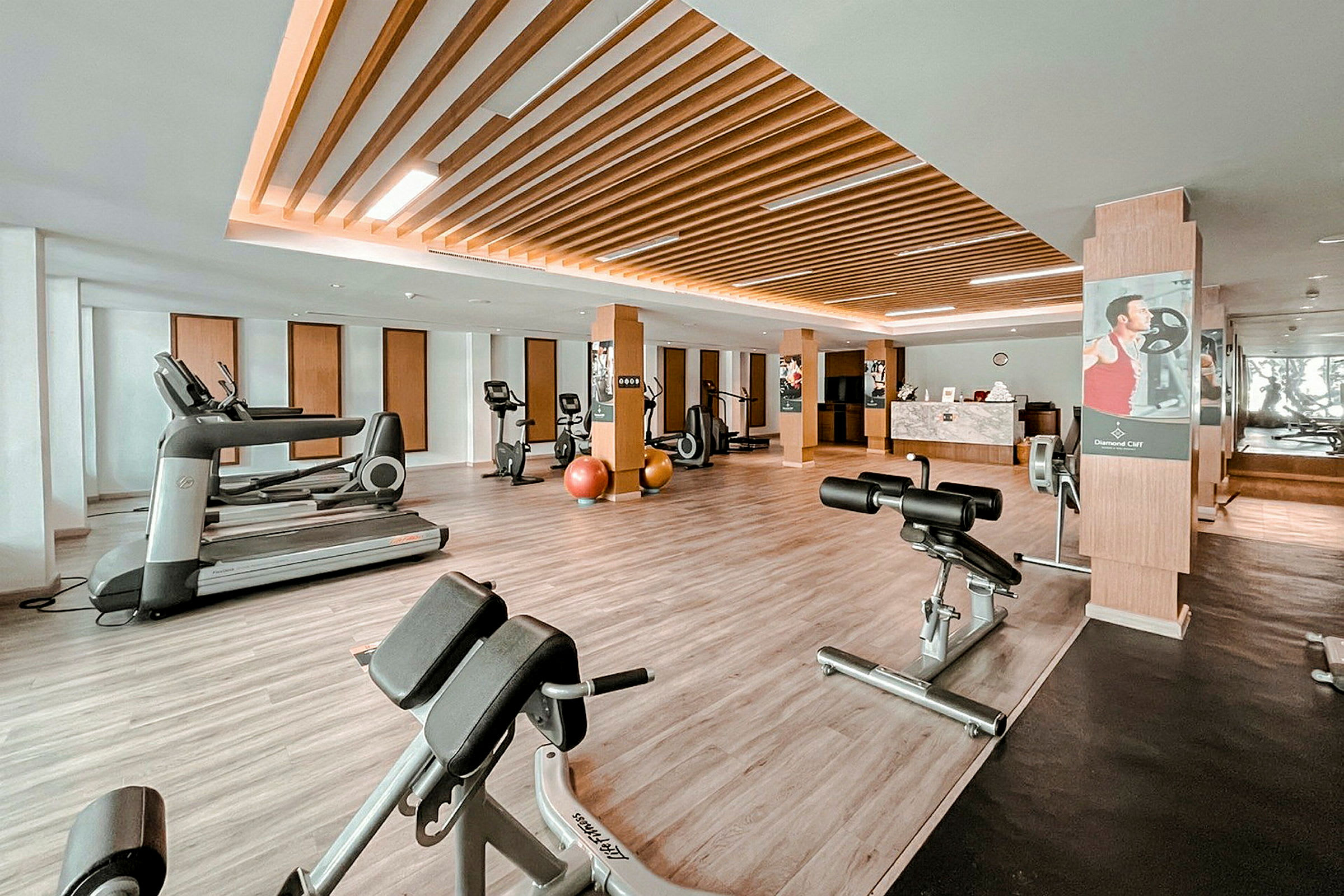 Et moderne fitnesscenter med træningsmaskiner og udstyr på et stilfuldt trægulv. (AI-genereret tekst)