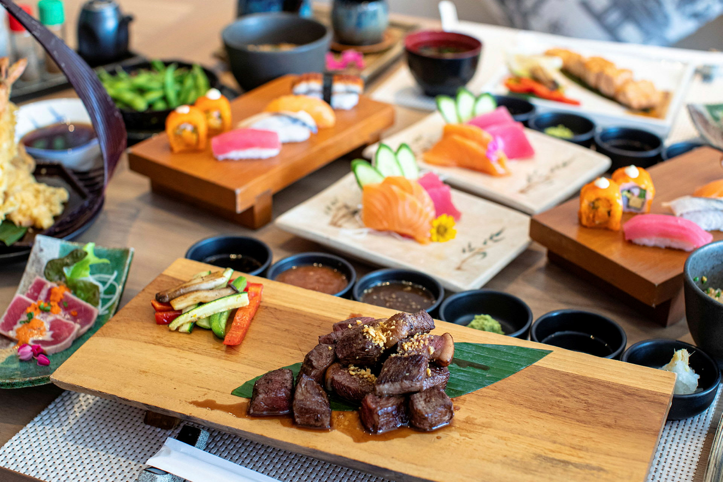 Et udvalg af japanske retter, herunder sushi og grillet kød. (AI-genereret tekst)