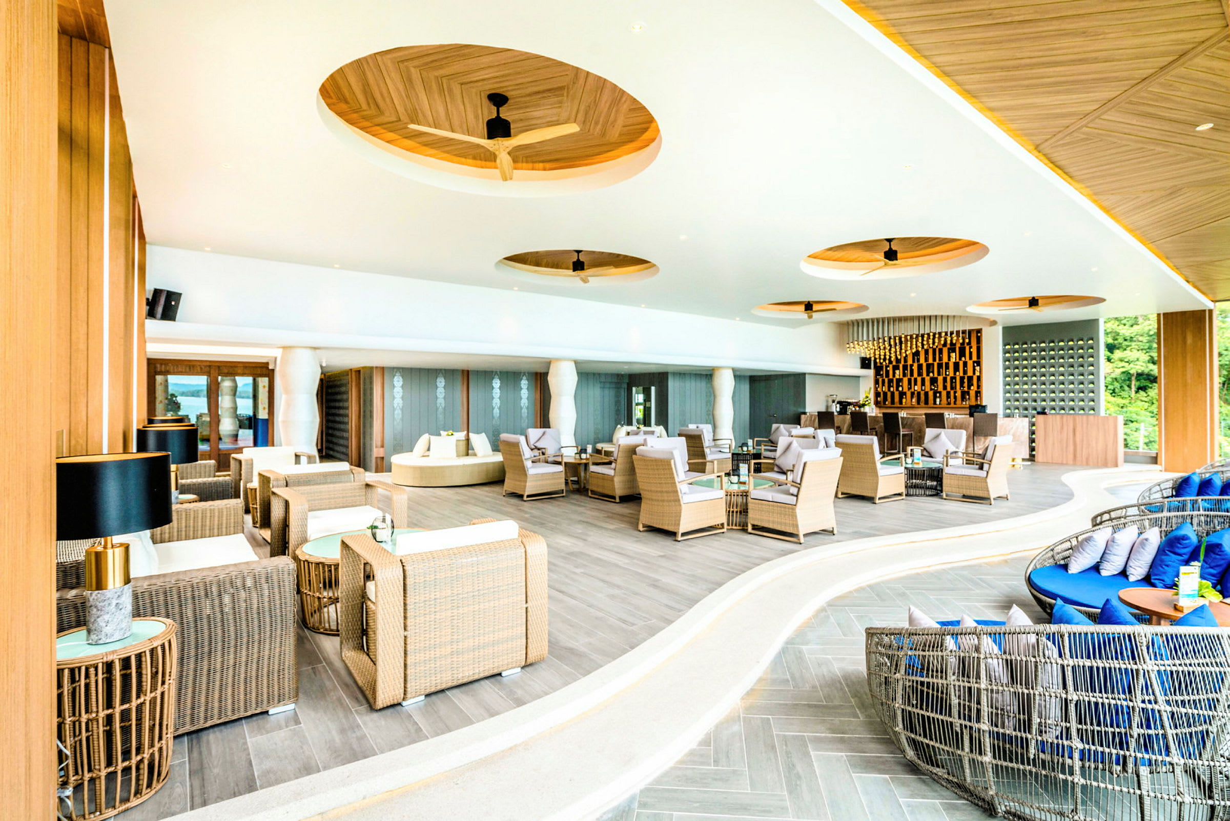 Moderne indrettet lounge med rottingmøbler og elegant design. (AI-genereret tekst)