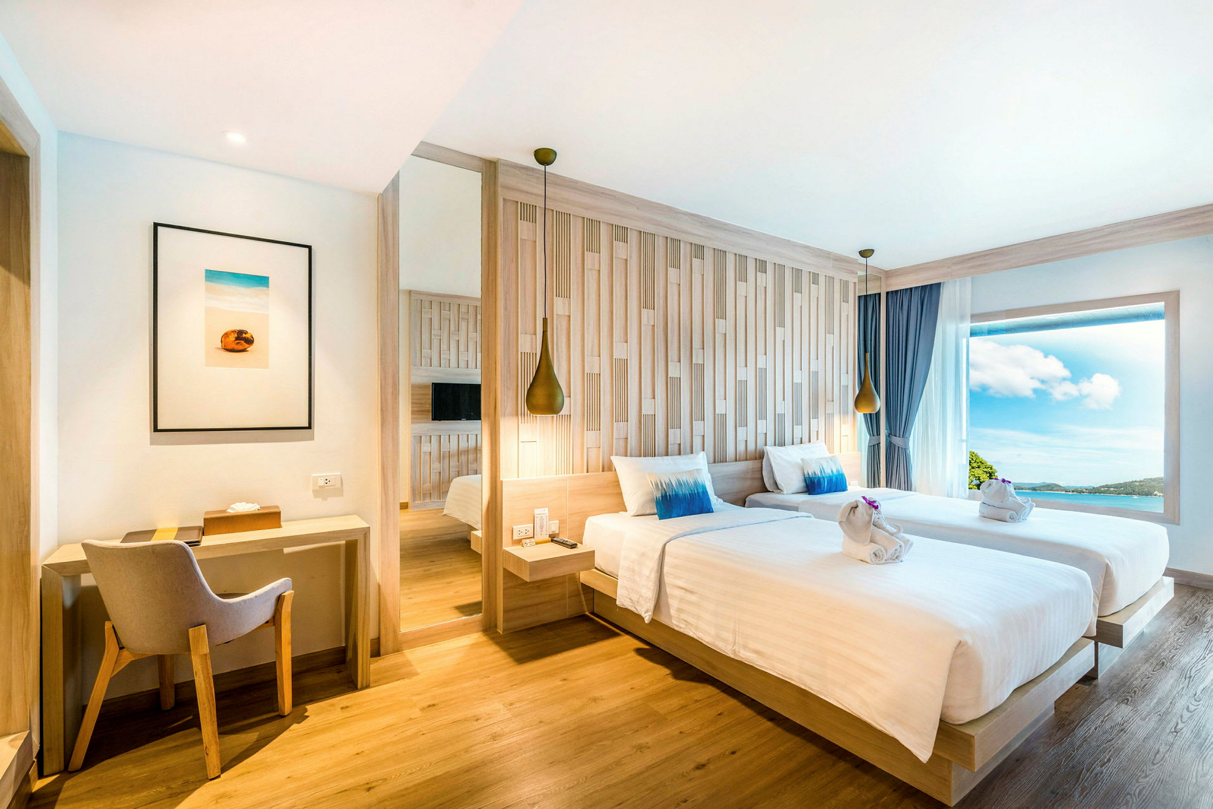 Moderne indrettet hotelværelse med to enkeltsenge, skrivebord og stort vindue med udsigt. (AI-genereret tekst)