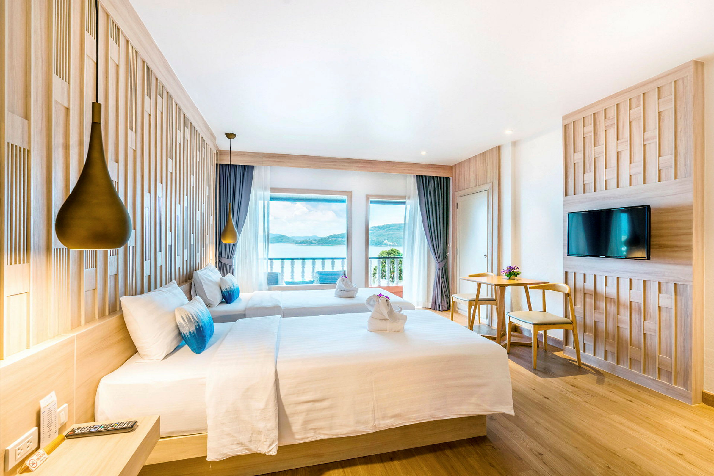 Hotelværelse med to senge, udsigt over havet og moderne indretning. (AI-genereret tekst)