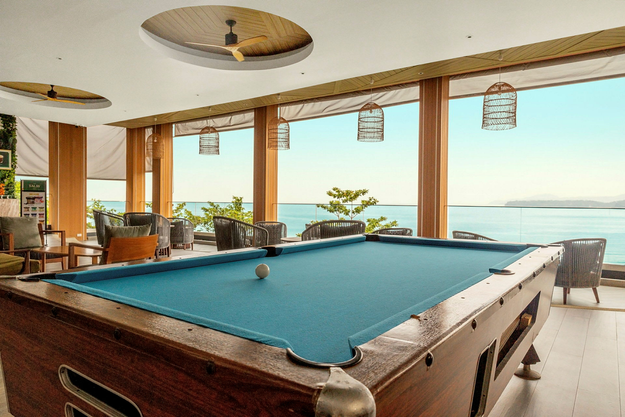 Poolbord i en lys lounge med udsigt til havet. (AI-genereret tekst)