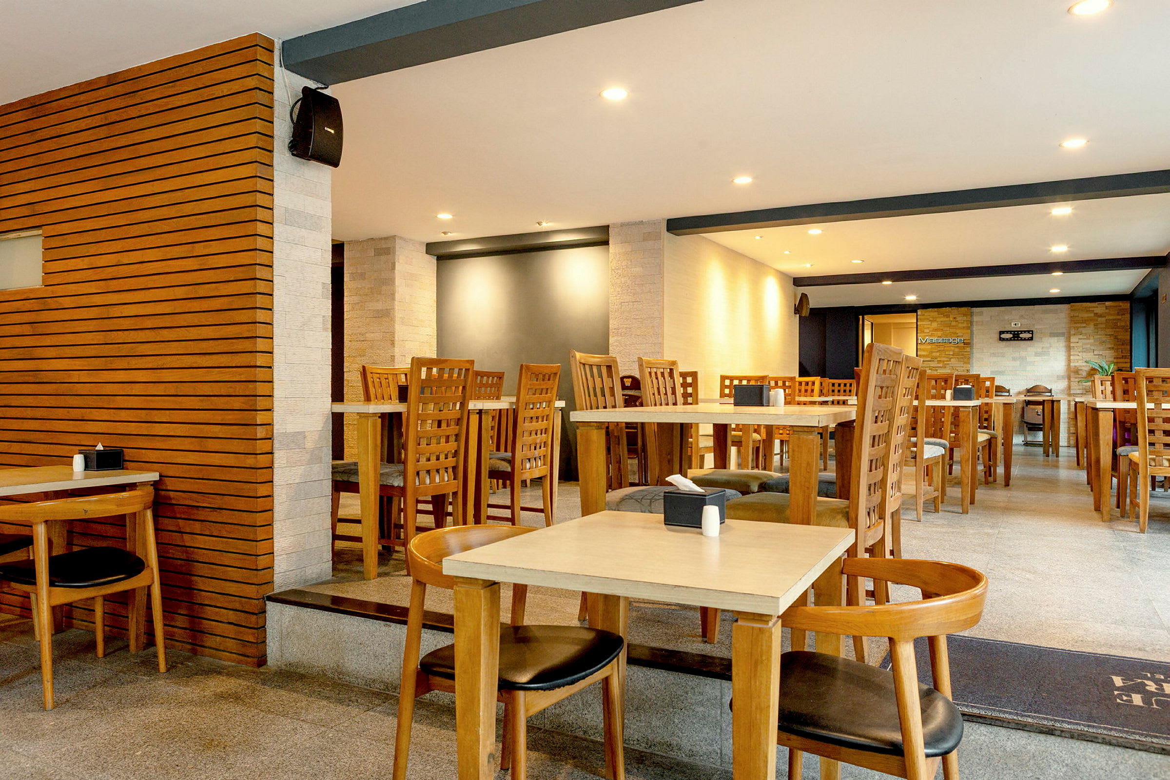 En restaurant med borde og stole i træ samt en moderne indretning. (AI-genereret tekst)