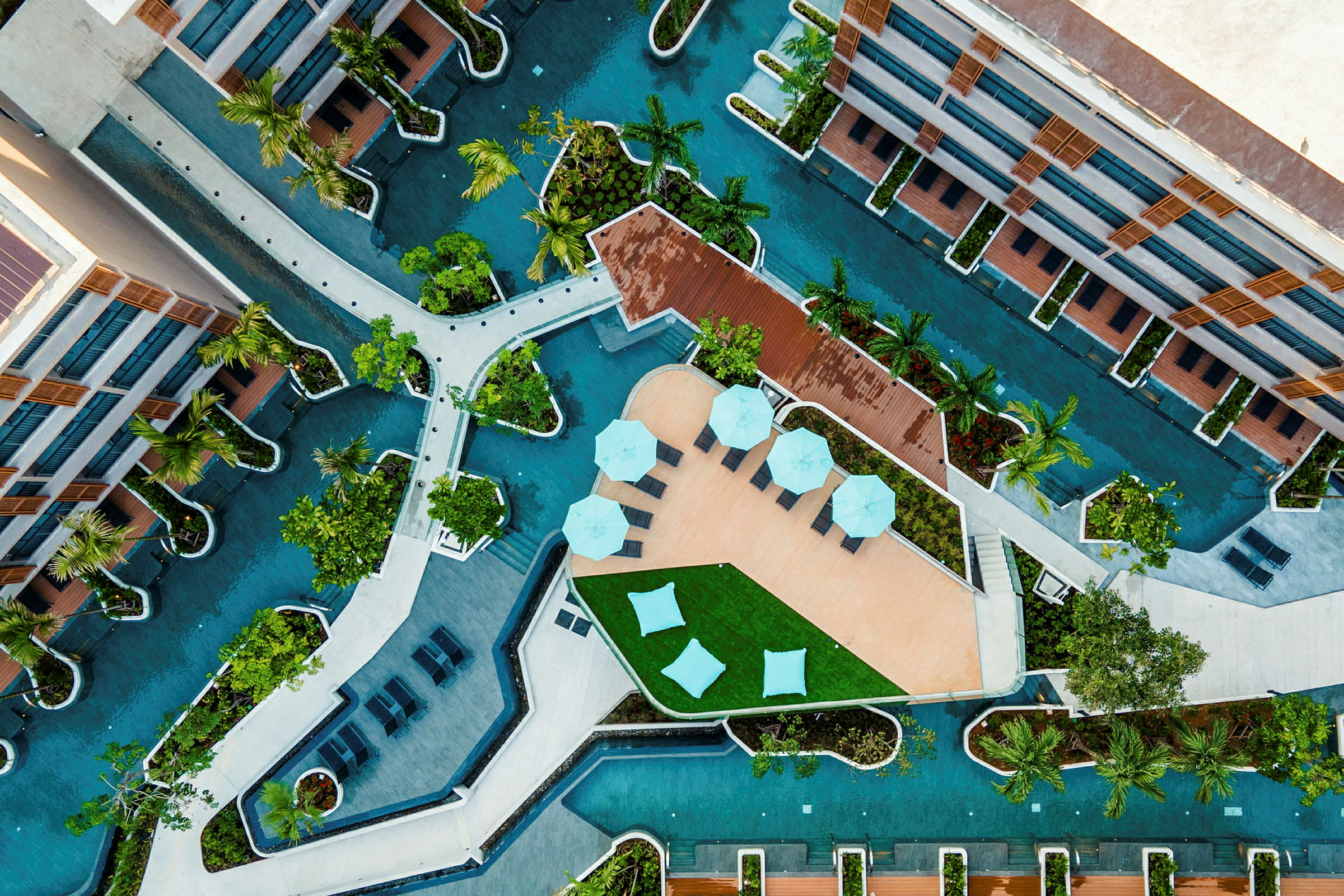 Luftfoto af en moderne faciliteter med udendørs swimmingpools, terrasser og grønne områder. (AI-genereret tekst)