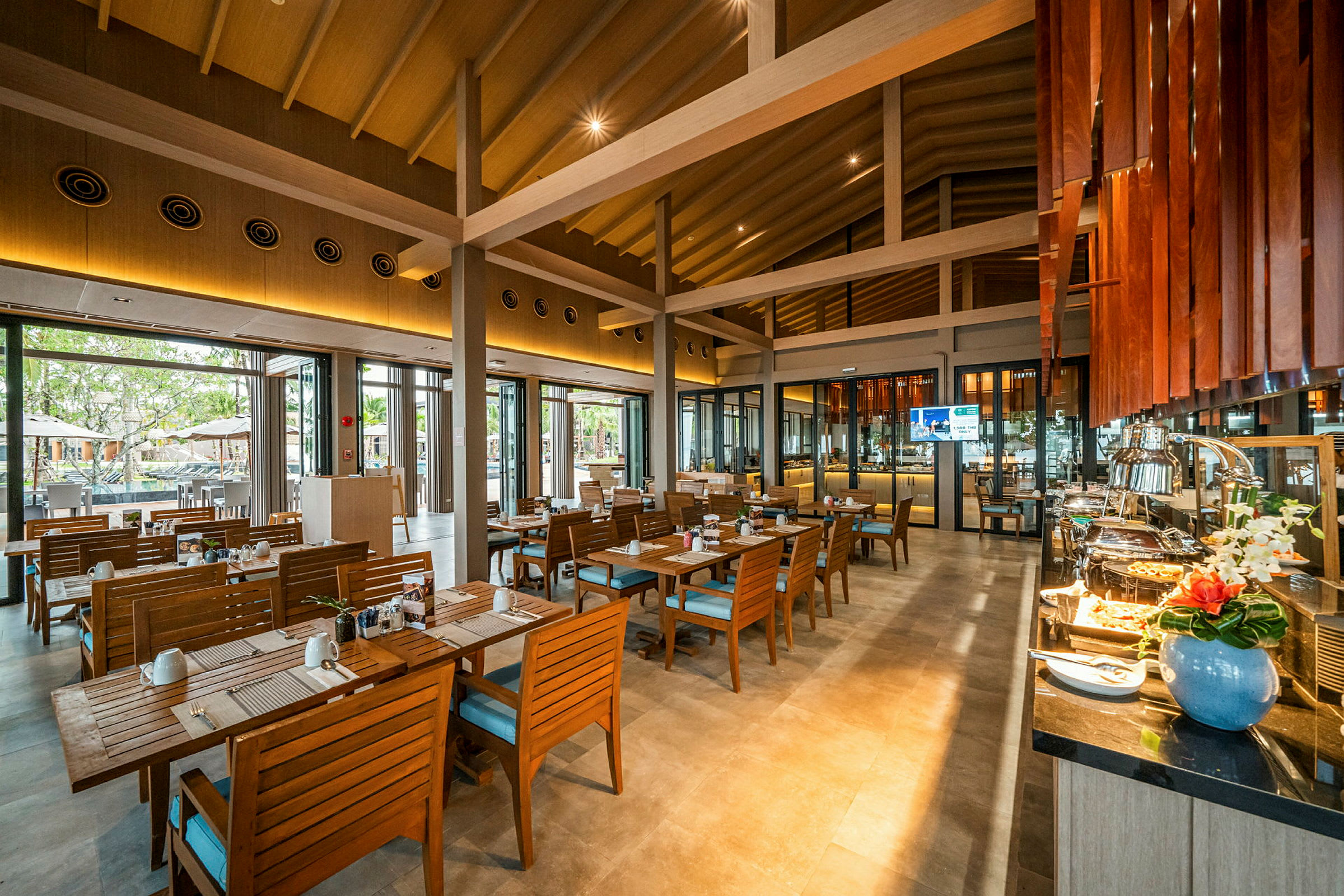 Et rummeligt restaurantområde med træinteriør, siddepladser og en buffet. (AI-genereret tekst)