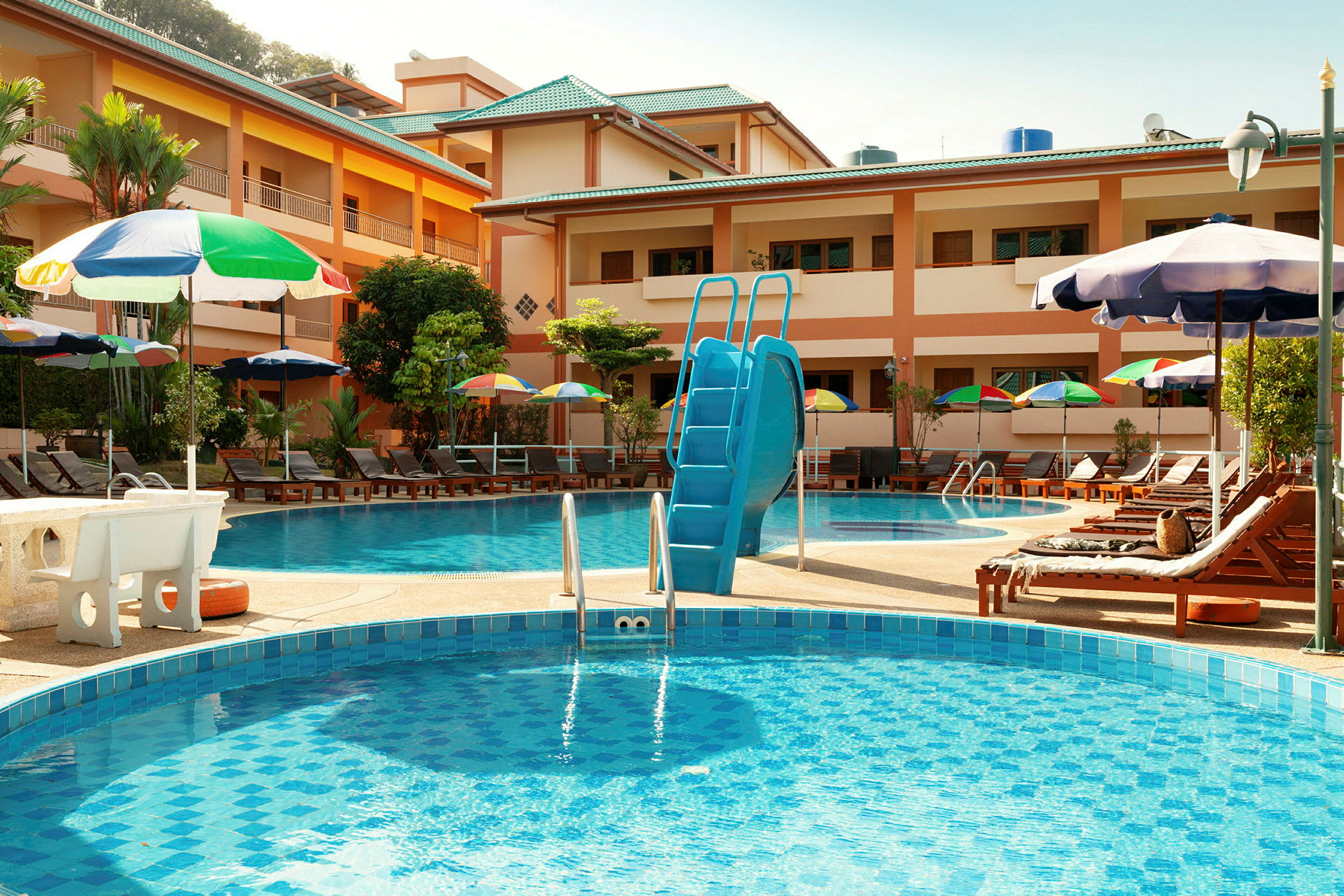 Hotel poolområde med liggestole og parasoller. (AI-genereret tekst)