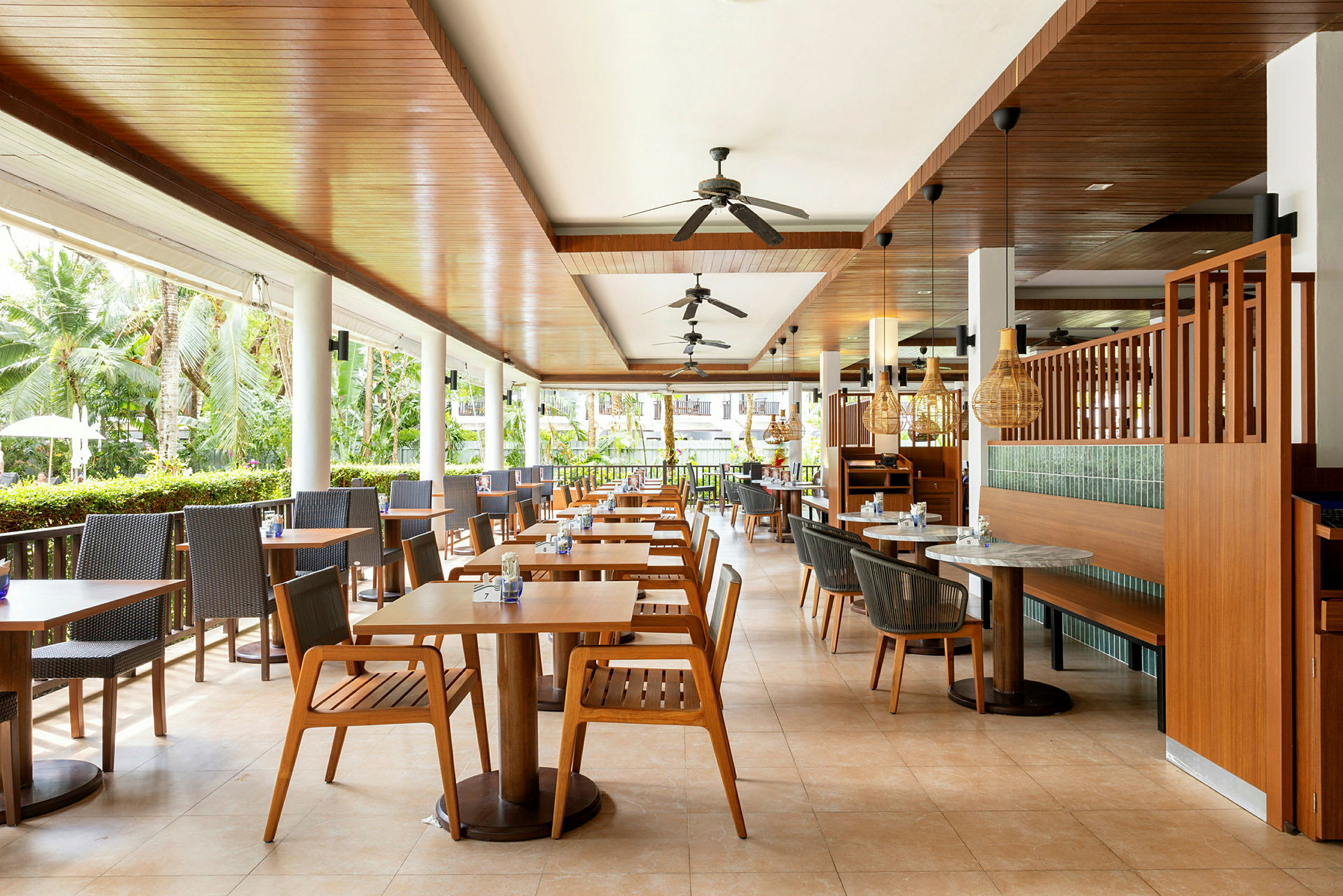 Restaurant med udendørsborde og siddepladser i træ. (AI-genereret tekst)