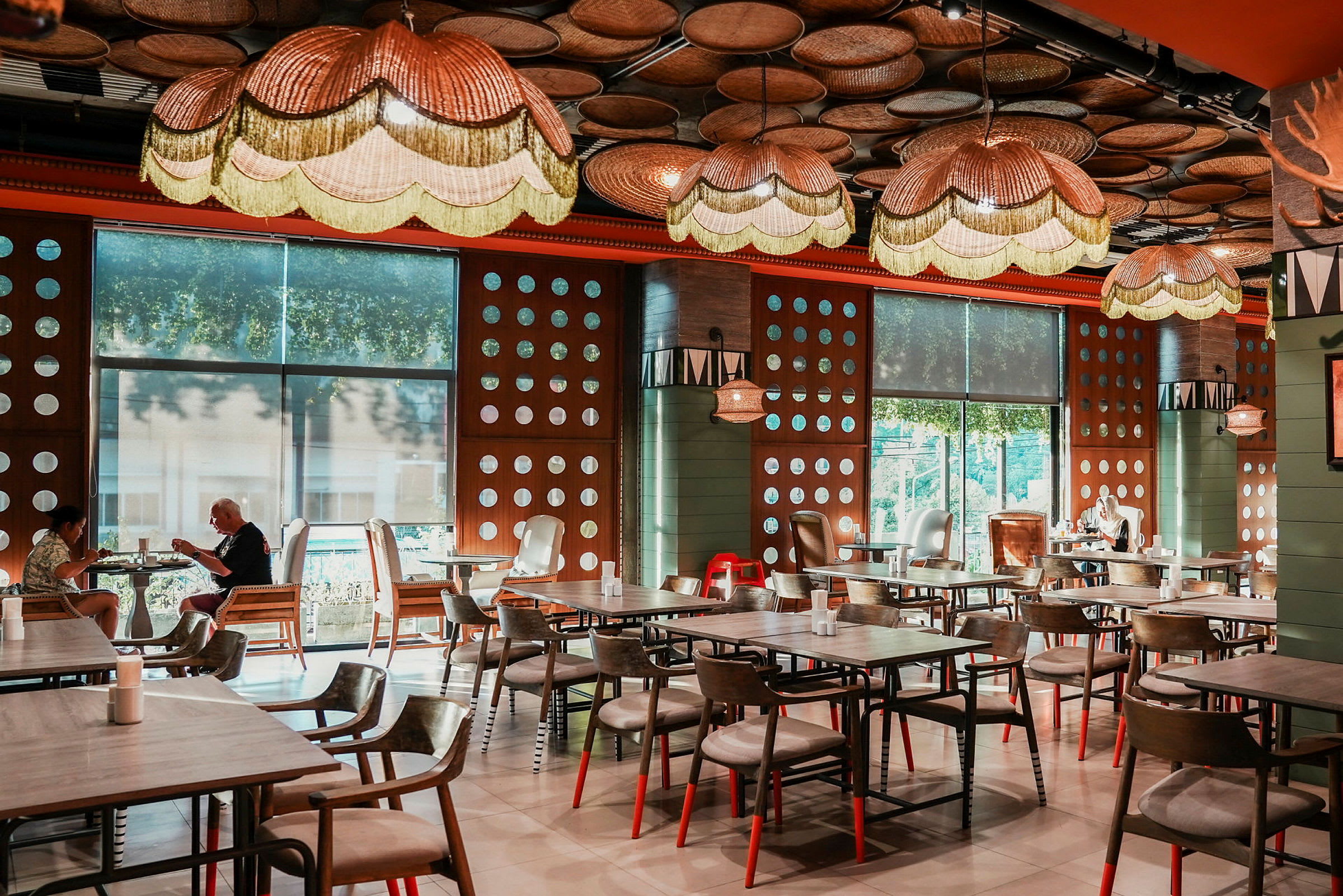 Et moderne indrettet restaurantområde med pæne trælampeskærme og borde til gæster. (AI-genereret tekst)