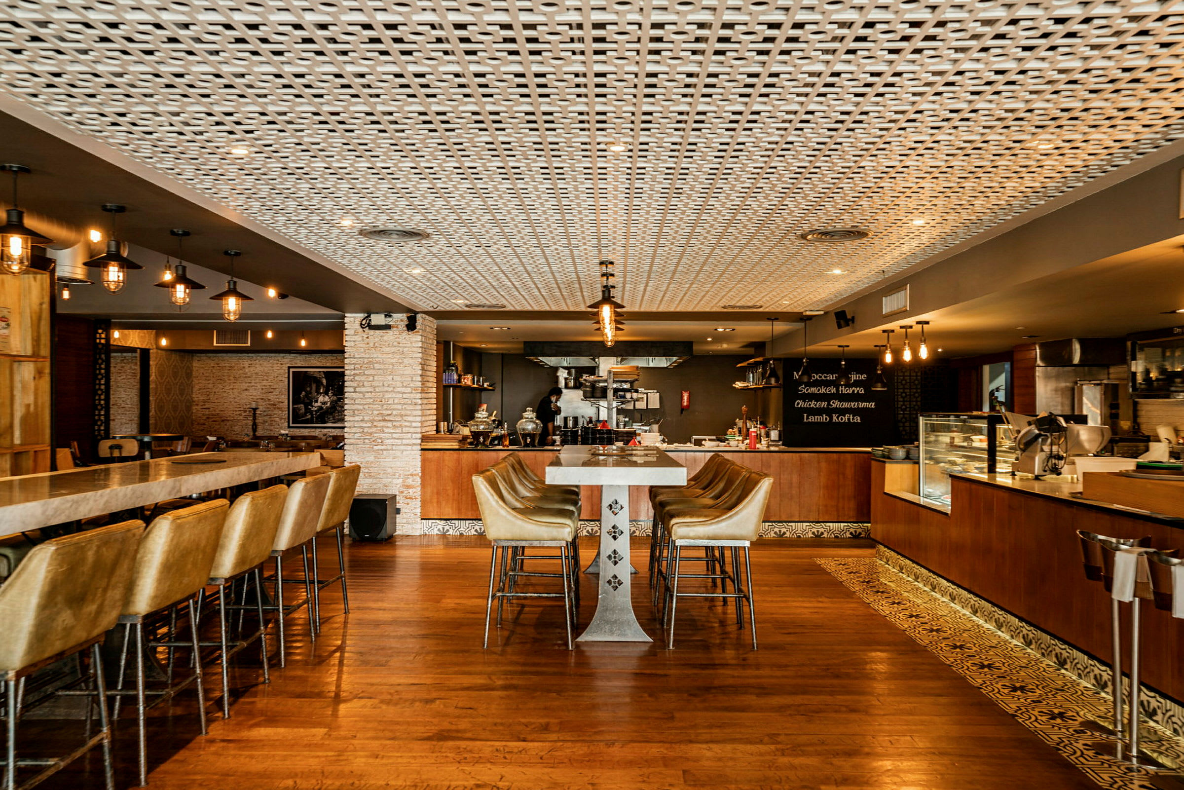 Interiør af en moderne restaurant med stilfuldt indrettet bar og siddegrupper. (AI-genereret tekst)