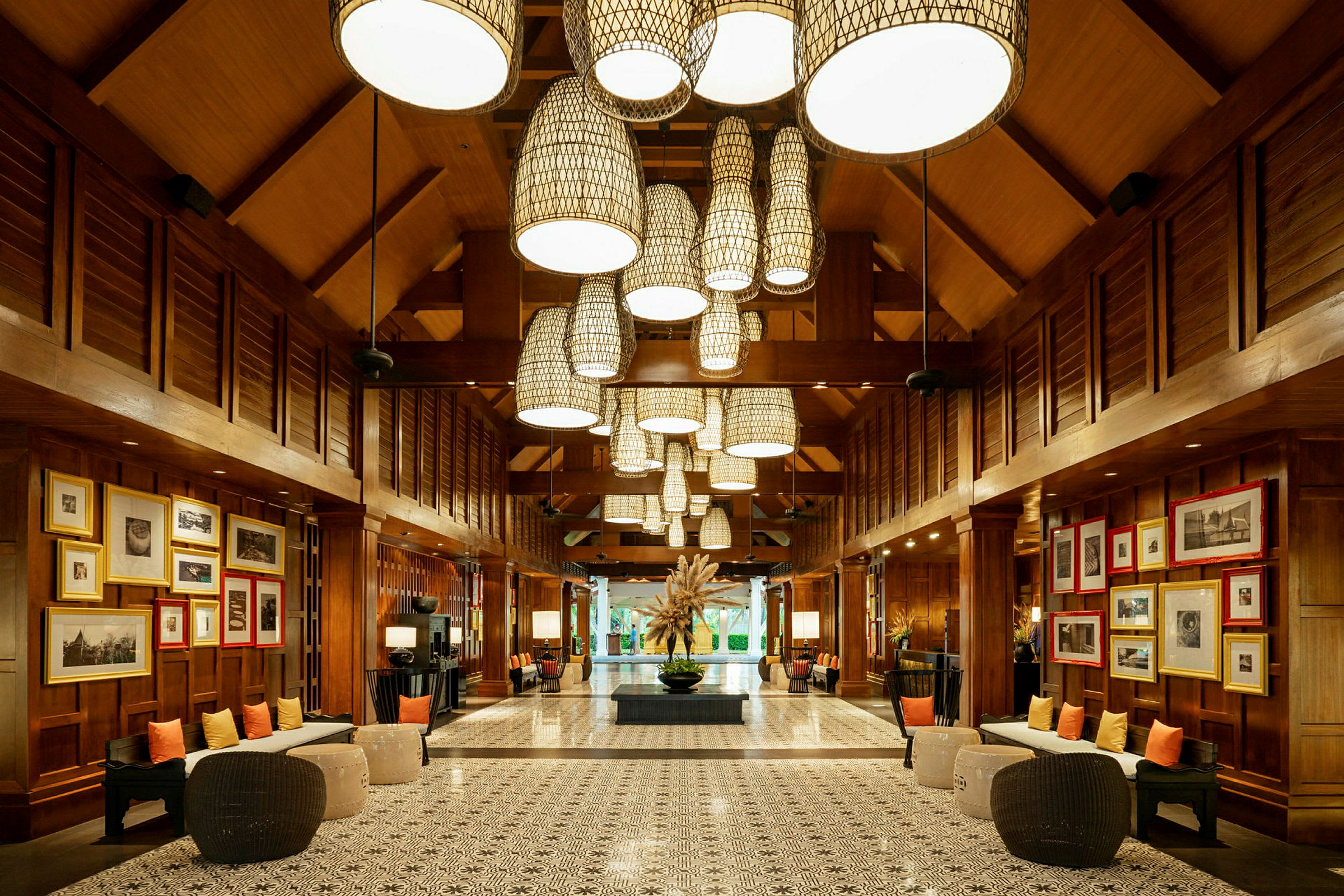Billede af en elegant hotellobby med træpaneler, dekorative lysarmaturer i loftet og kunstværker på væggene. (AI-genereret tekst)