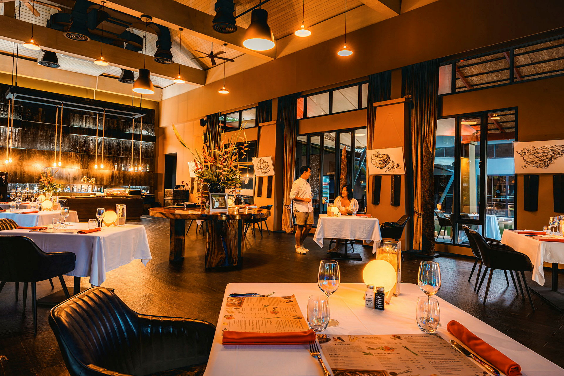 Restaurant med dækkede borde i en stilfuld og elegant indendørs omgivelser. (AI-genereret tekst)