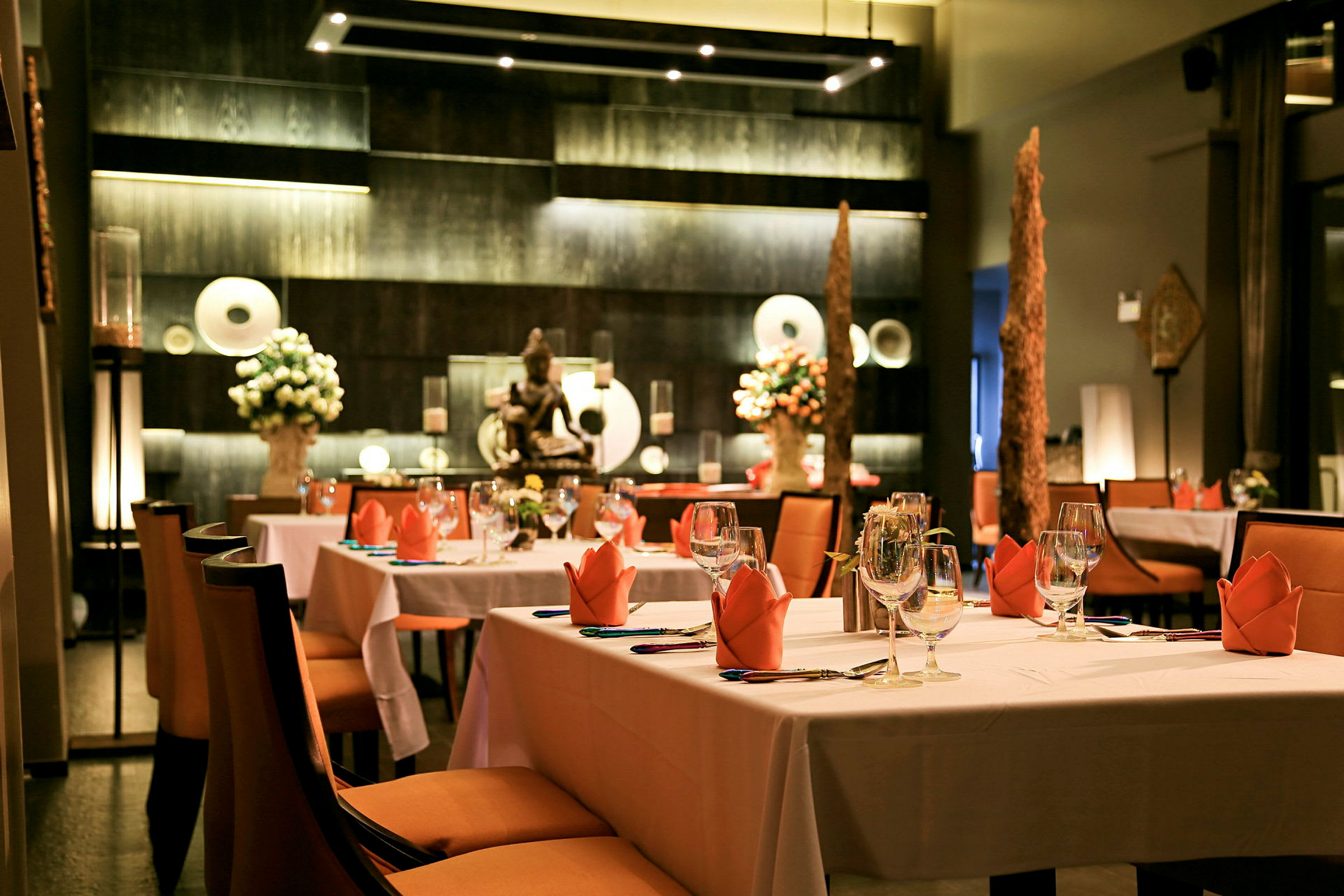 En stilfuldt indrettet restaurant med dækkede borde og dekorationer. (AI-genereret tekst)