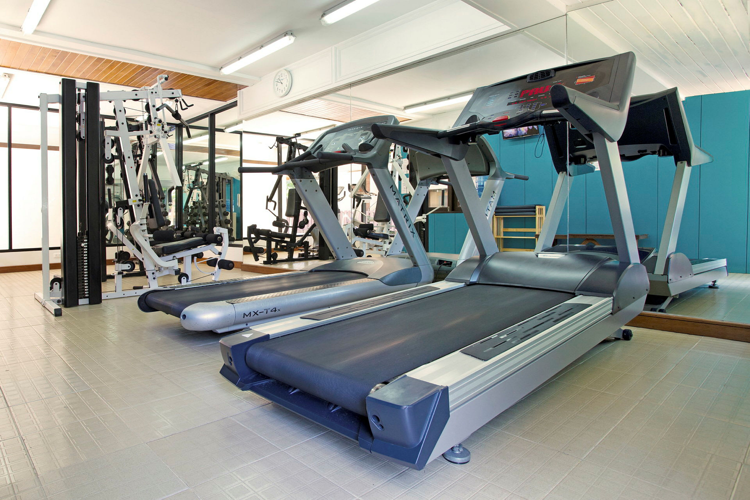 Fitnessrum med løbebånd og træningsmaskiner. (AI-genereret tekst)