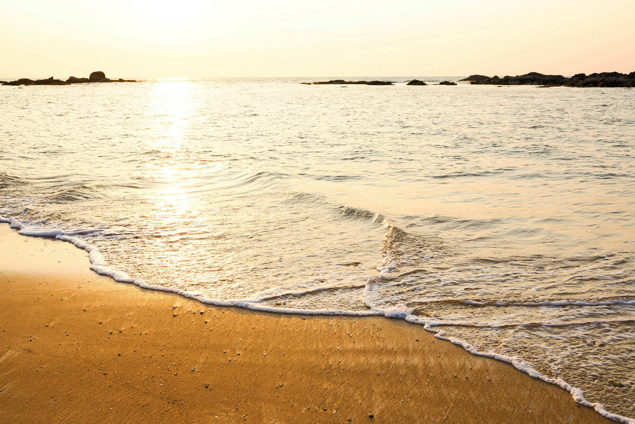 En strand ved havet med solnedgang. (AI-genereret tekst)