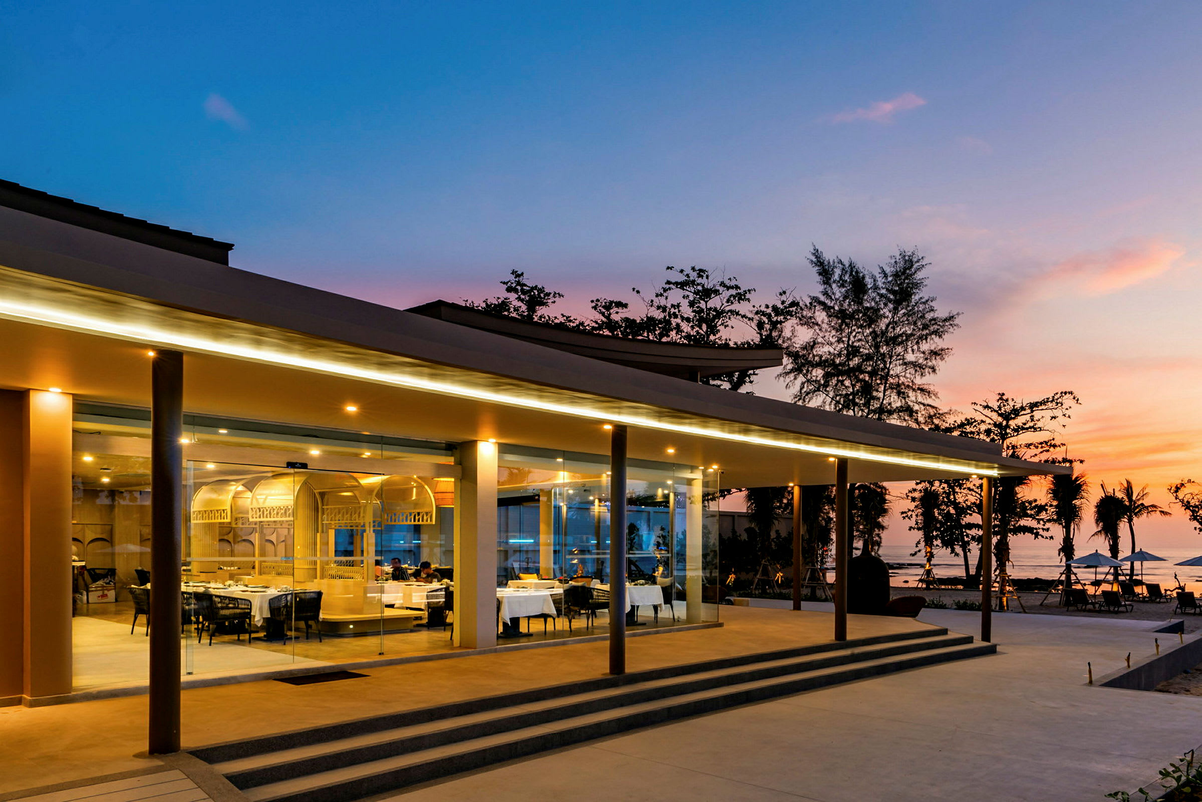 Restaurant med glasfacade i solnedgang. (AI-genereret tekst)