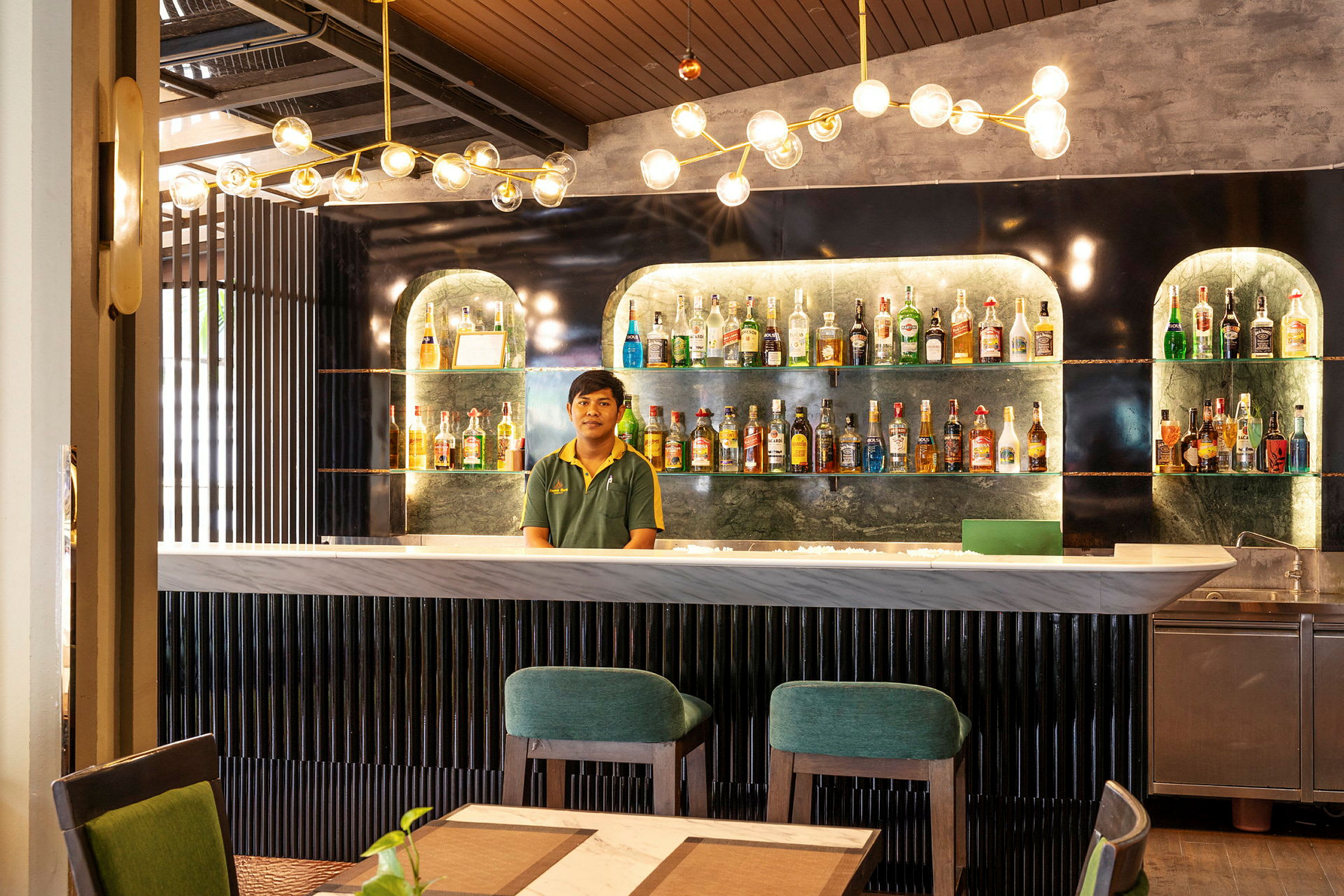 En moderne bar med flasker opstillet på hylder og moderne møbler. (AI-genereret tekst)