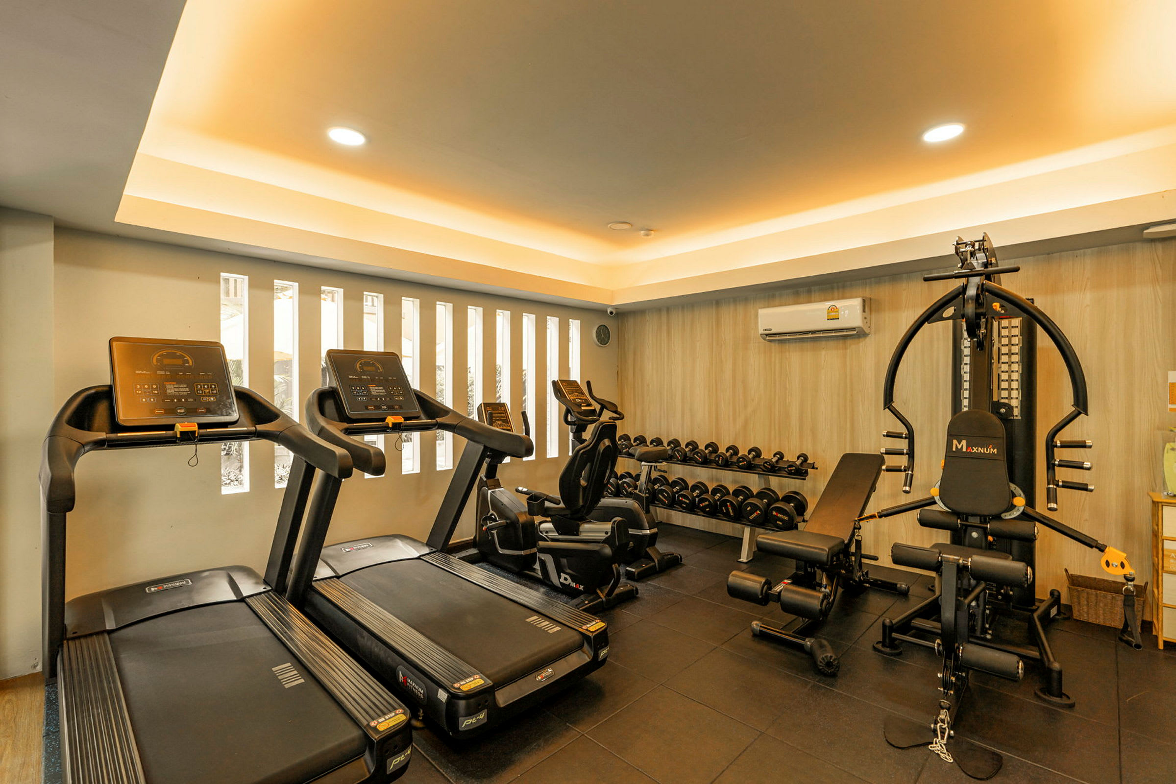 Et moderne fitnesscenter med løbebånd, motionscykler, vægtmaskiner og en række håndvægte. (AI-genereret tekst)