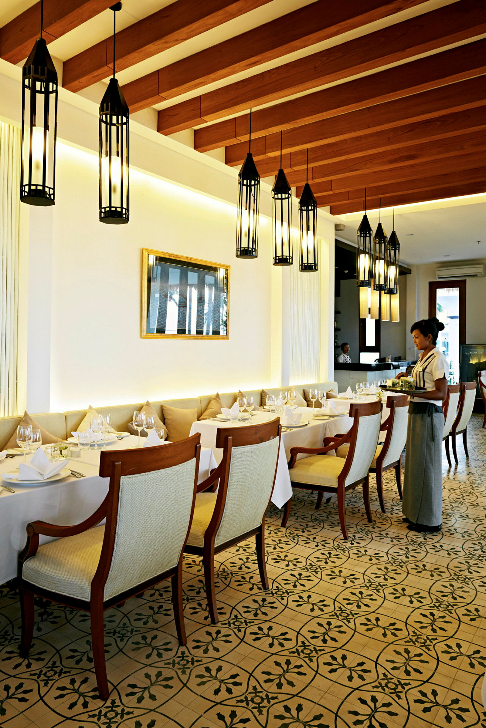 Elegant restaurant med dækkede borde og pendellamper i loftet. (AI-genereret tekst)