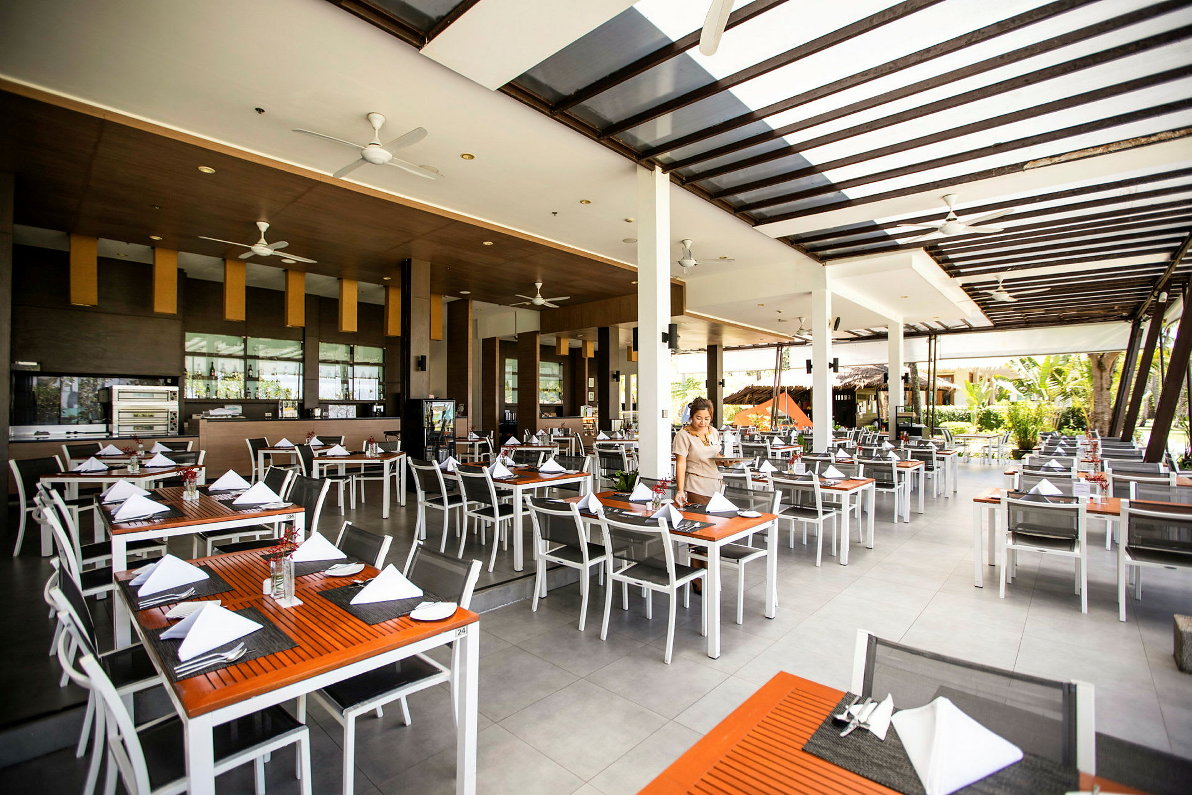 Restaurant med dækkede borde og moderne møbler. (AI-genereret tekst)